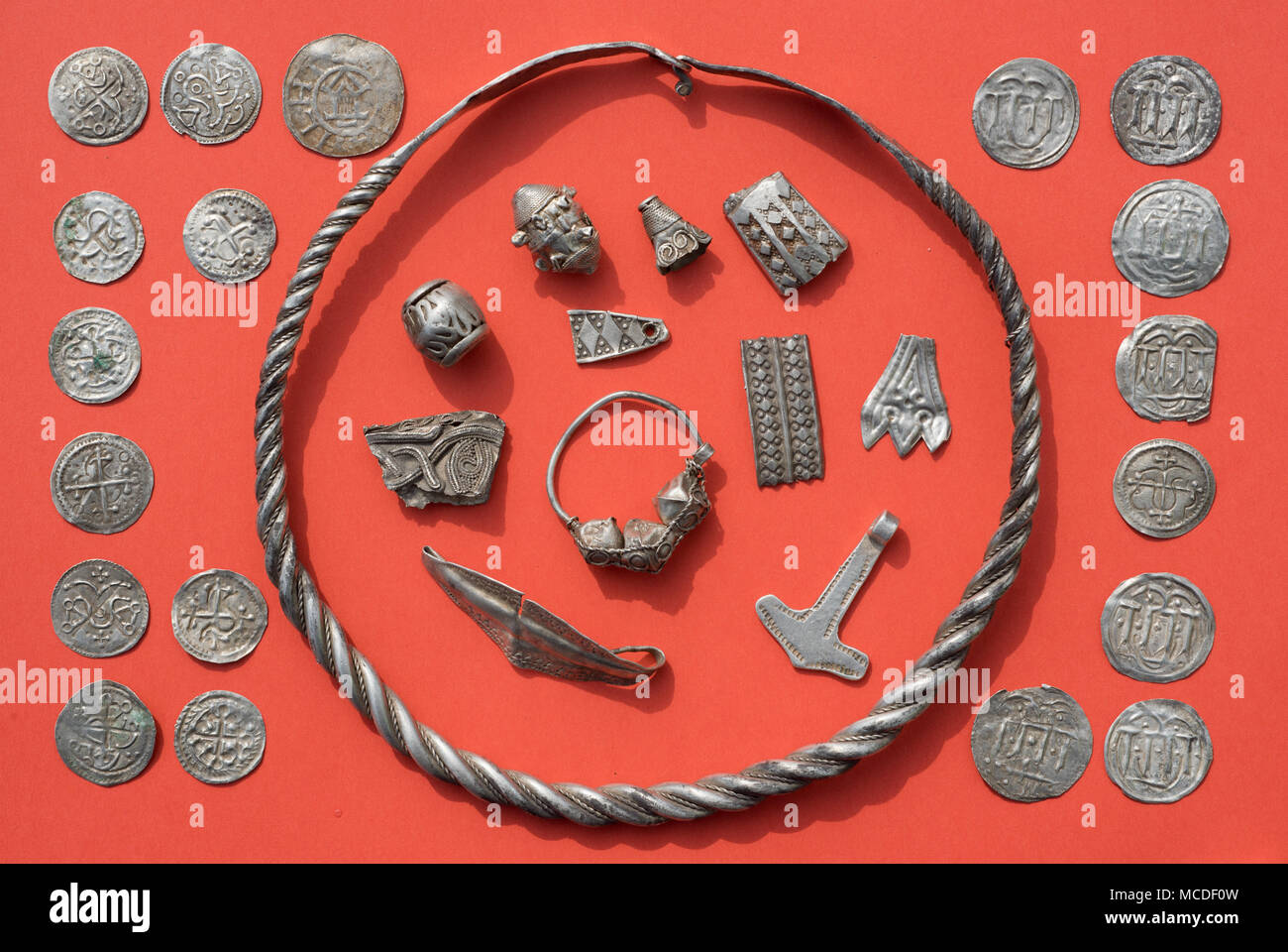 13 de abril de 2018, Alemania, Schaprode: Algunos de los tesoros de plata Schaprode, incluyendo un anillo espiral de plata, perlas, joyas de plata cut-up, el martillo de Thor, de amuleto y danés y Ottonian monedas en una tabla. Los arqueólogos han descubierto valiosos tesoros de plata escandinavo, predominantemente desde finales del siglo 10, en un campo en la isla alemana de Ruegen. En un área de unos 400 metros cuadrados, cerca del municipio de Schaprode, se recuperaron joyas y alrededor de 500 - 600 monedas, de las cuales más de 100 monedas se remontan al reinado del rey danés Harald "Bluetooth" (910-987). Foto: Stef Foto de stock