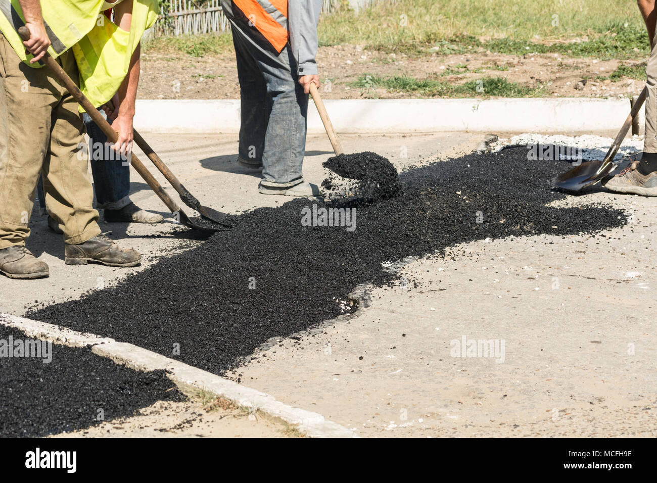 Detalles de reparación de carreteras. Los trabajadores se quedan dormidos con asfalto caliente fosos en la carretera. Foto de stock