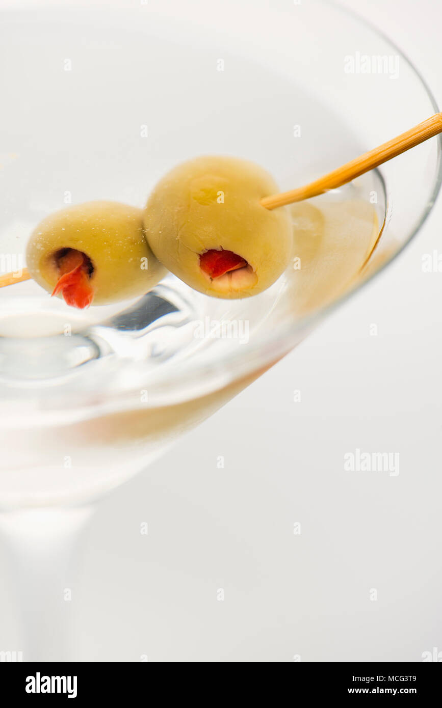 De cerca una dirty martini con aceitunas. Foto de stock