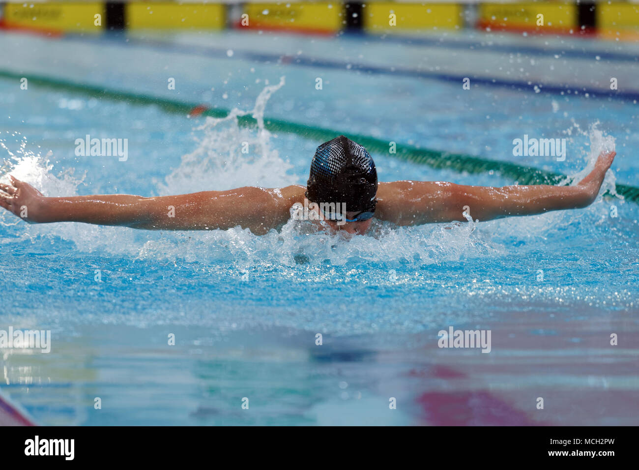 San Petersburgo, Rusia - Abril 11, 2018: Los hombres compiten en 100m mariposa natación durante las competiciones de natación All-Russian Merry Dolphin. El competitio Foto de stock