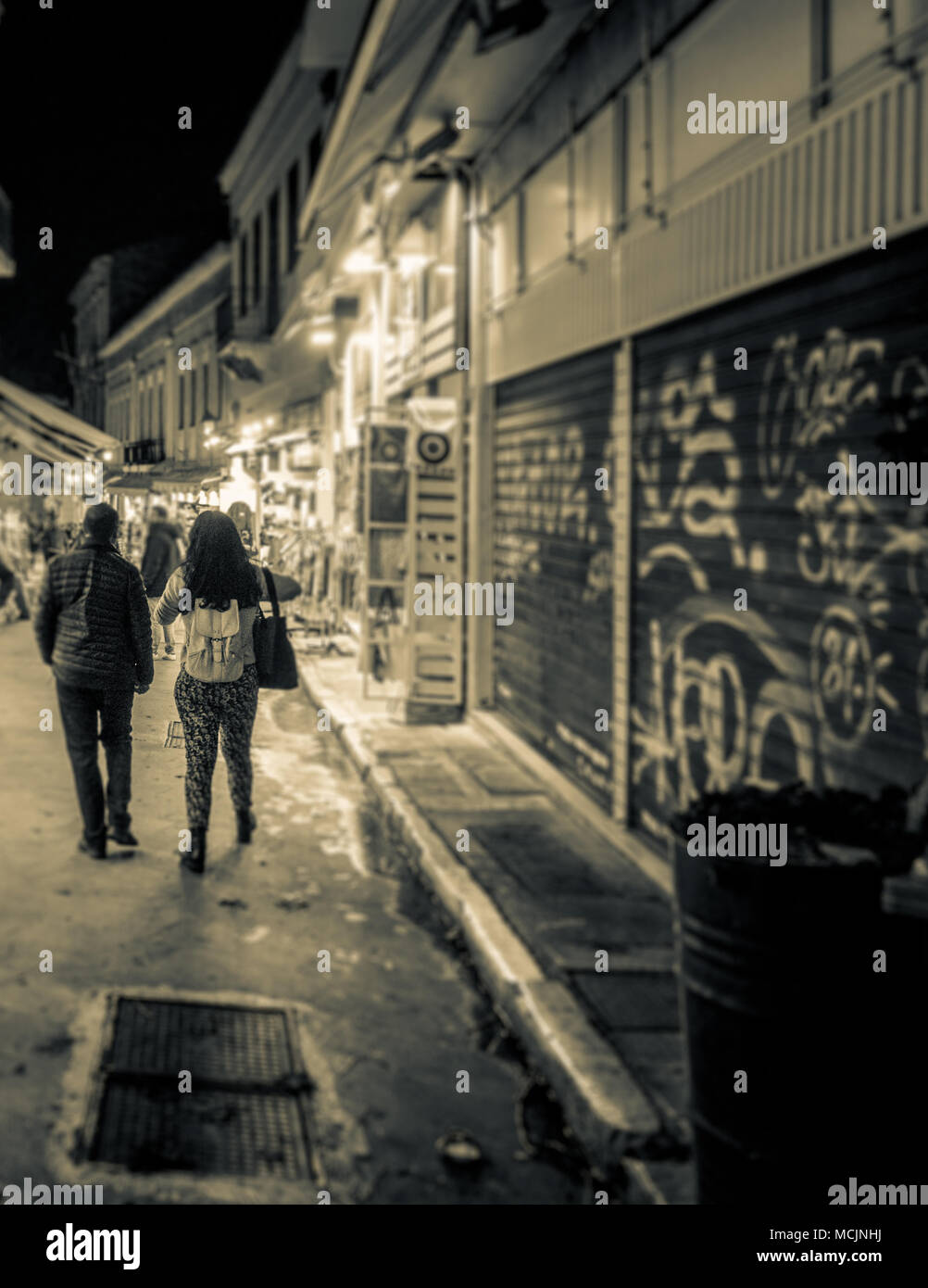 Vista trasera de la pareja caminando por las calles de la ciudad, Atenas, Grecia Foto de stock