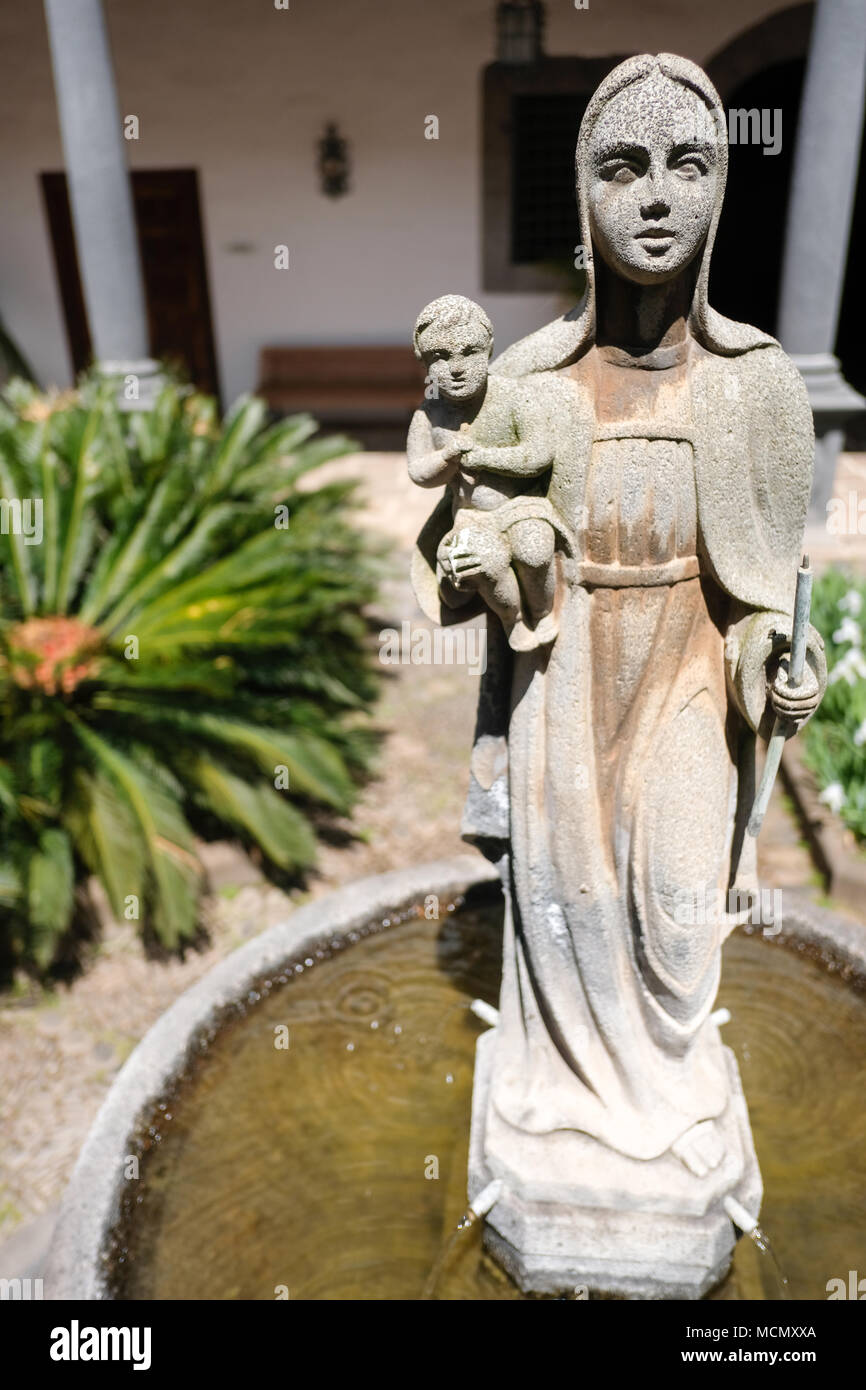 Un staue de una virgen y el niño como una fuente de agua en el patio de la casa colonial en La Laguna, Tenerife. Foto de stock
