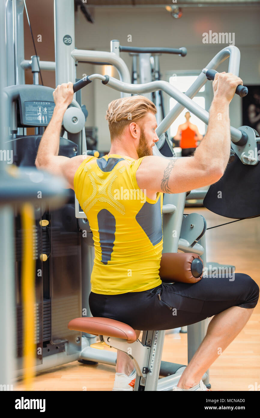 Vista trasera de una poderosa máquina de musculación con fuertes brazos  hacer ejercicio en el gimnasio Fotografía de stock - Alamy