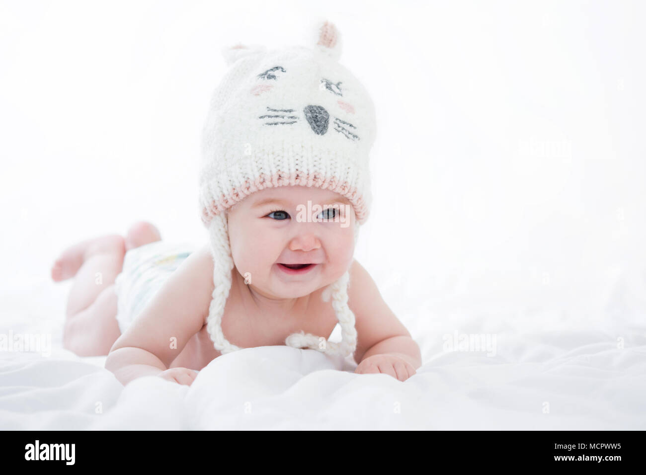 Adorable pequeño bebé chica sonriente sobre fondo blanco Adorable hijita sonriendo sobre fondo blanco. Foto de stock