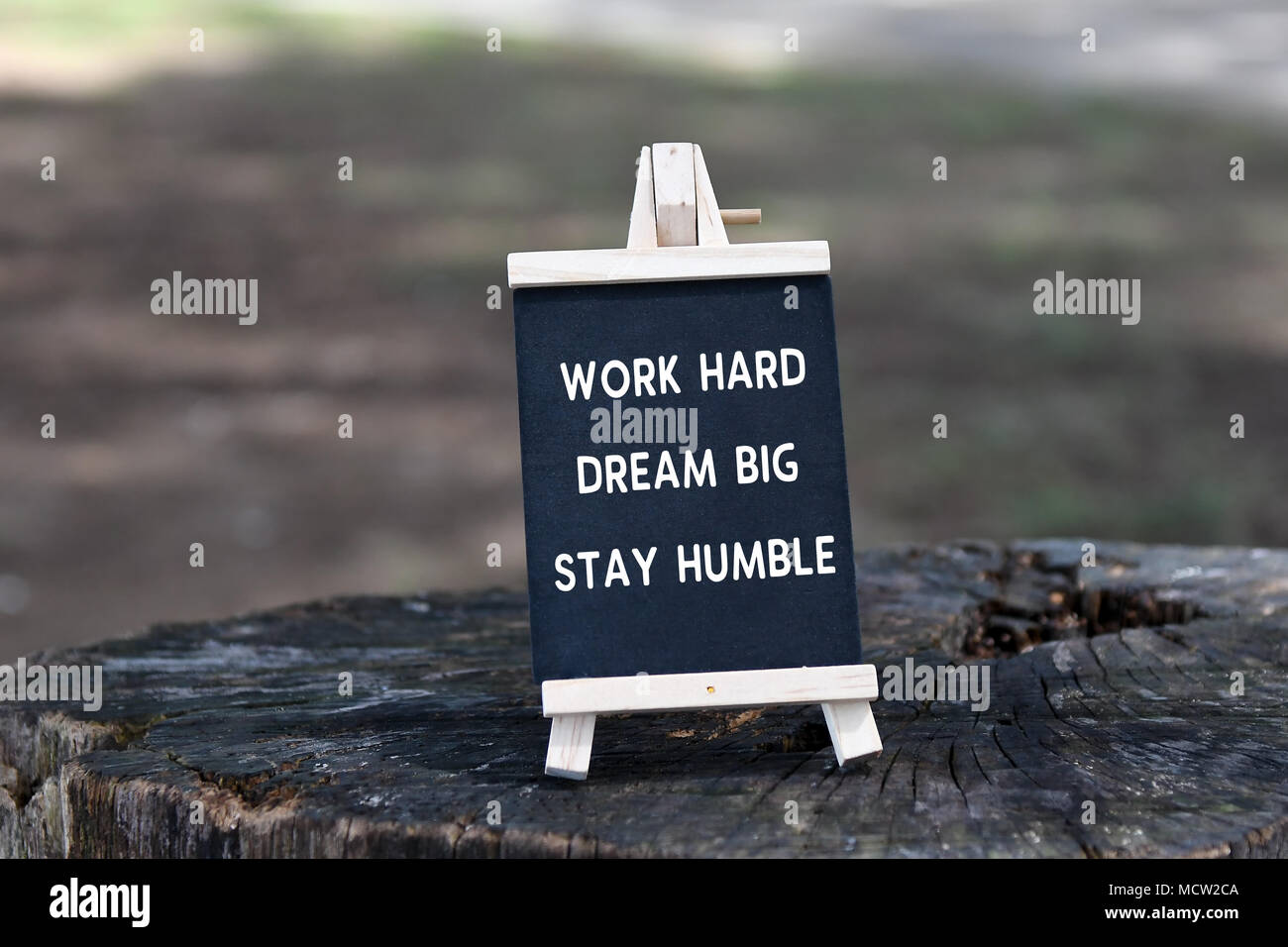 Cita inspiradora - Trabajar duro, soñar en grande, humilde, en junta de negro. Foto de stock