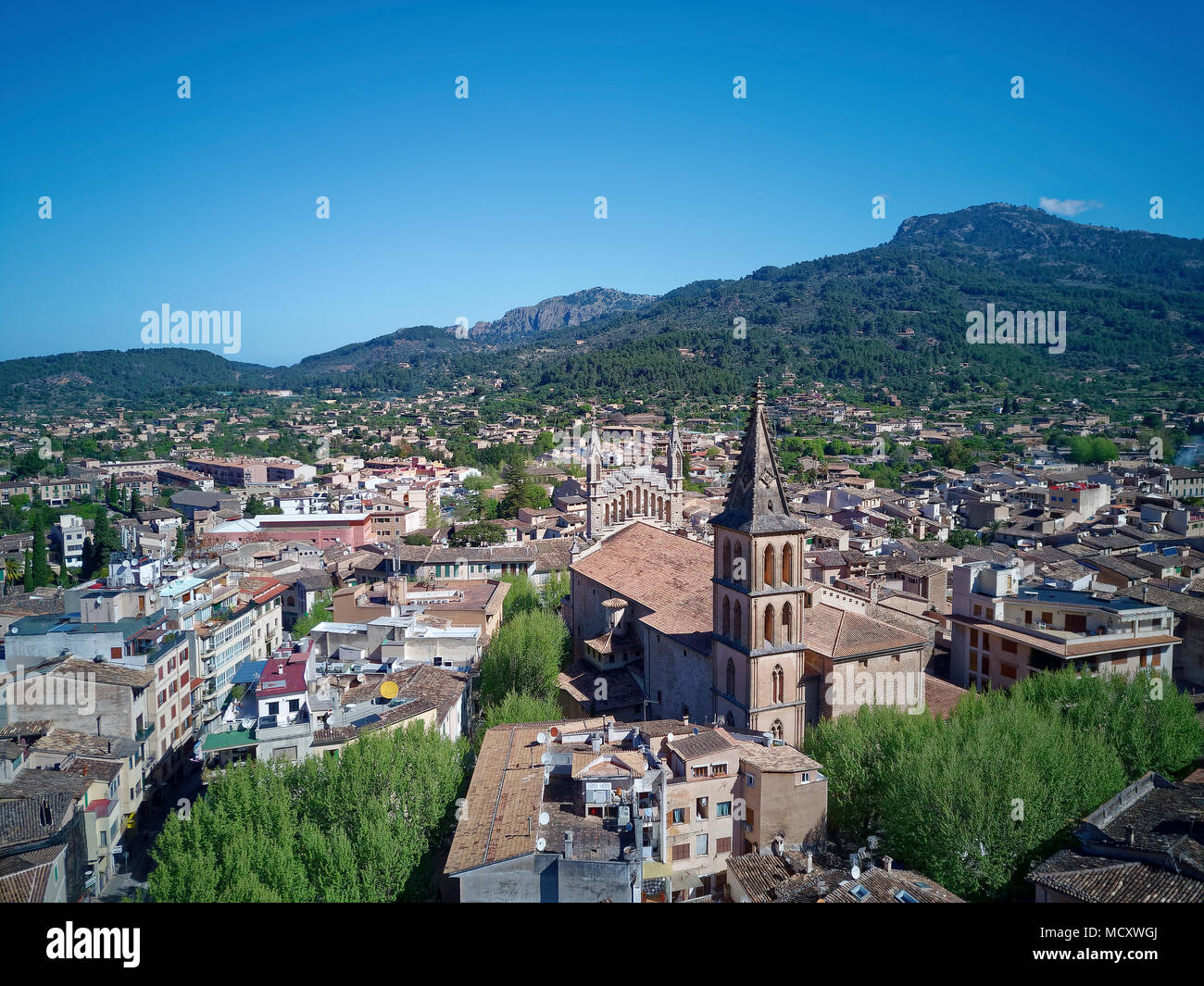 Vista de la ciudad vieja con la iglesia de San Bartolomé, Iglesia parroquial católica, Sóller, montañas en la parte posterior Foto de stock