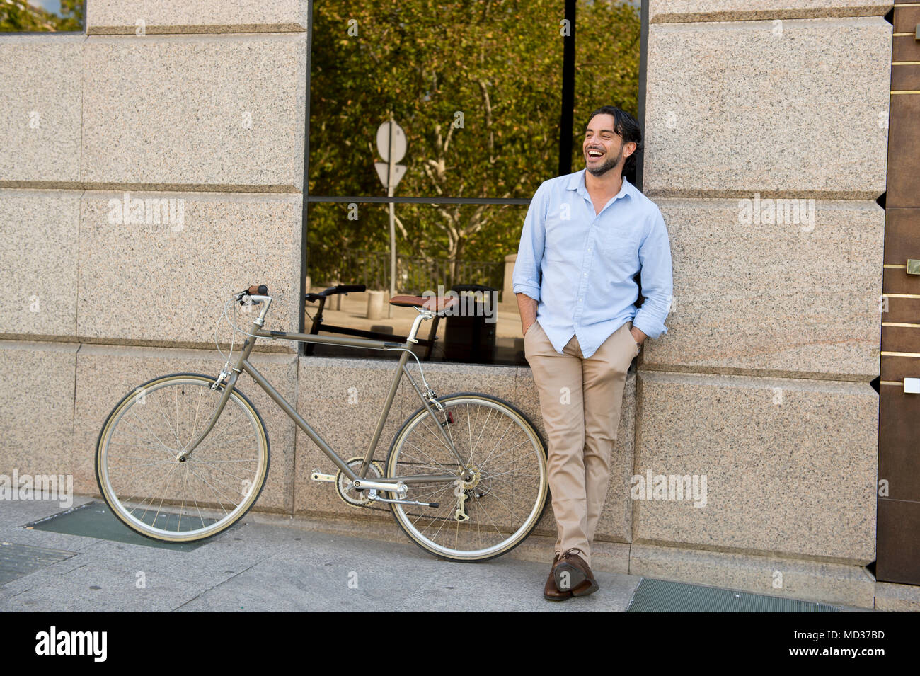Feliz joven atractivo hombre latino en ropa de moda casual sonriendo alegre  montando en bicicleta vintage cool retro en el estilo de vida moderno urban  styl Fotografía de stock - Alamy