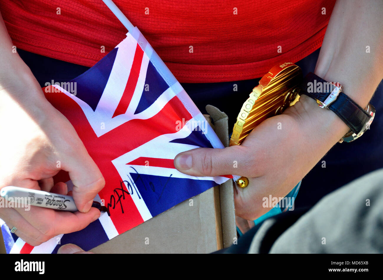 Lizzy Yarnold sostiene su medalla de oro en los Juegos Olímpicos de Invierno de 2018 como ella firma un pabellón para una escuela local, recorriendo los alrededores en Sevenoaks, Kent, en abril de 2018.... Foto de stock