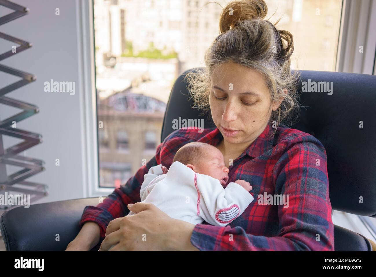 La madre con el niño dormido en casa Foto de stock