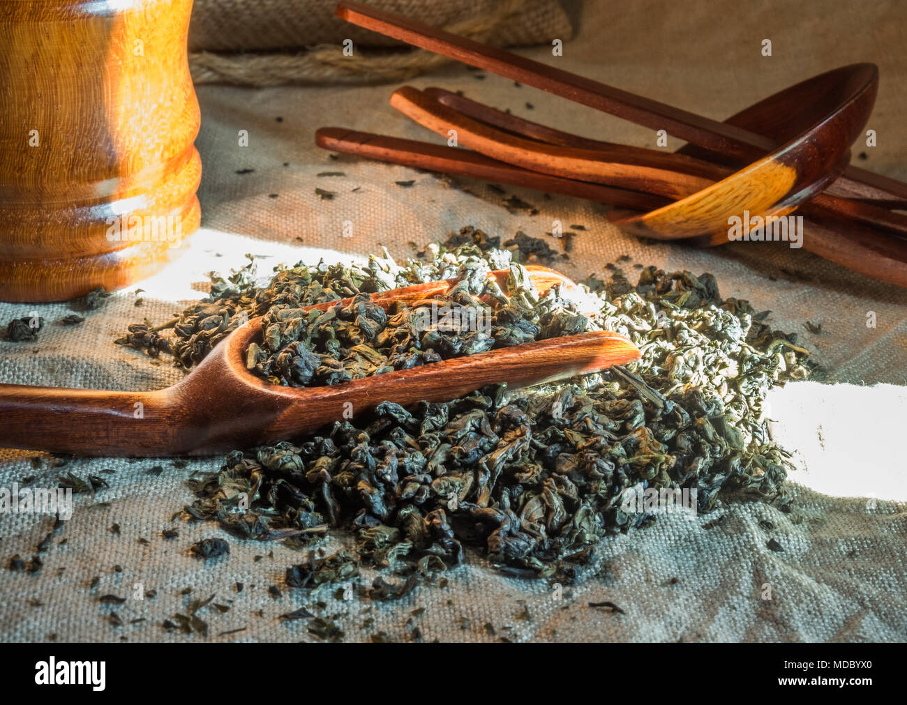 Oolong té chino. Montón de hojas de té en el mantel de lino con textura con cuchara de bambú. Aromática y saludable bebida ampliamente utilizado en el mundo. Foto de stock