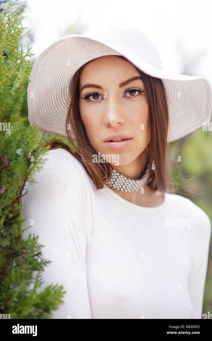 Retrato de bello modelo de vestido blanco y sombrero en la naturaleza antecedentes Foto de stock