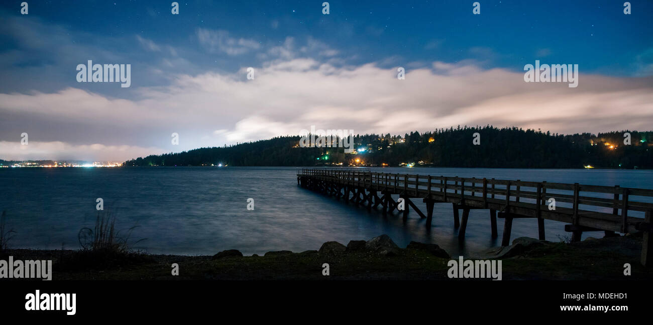 Imagen panorámica de luces en Shoreline a través del agua y Pier, Bainbridge, Washington, Estados Unidos Foto de stock