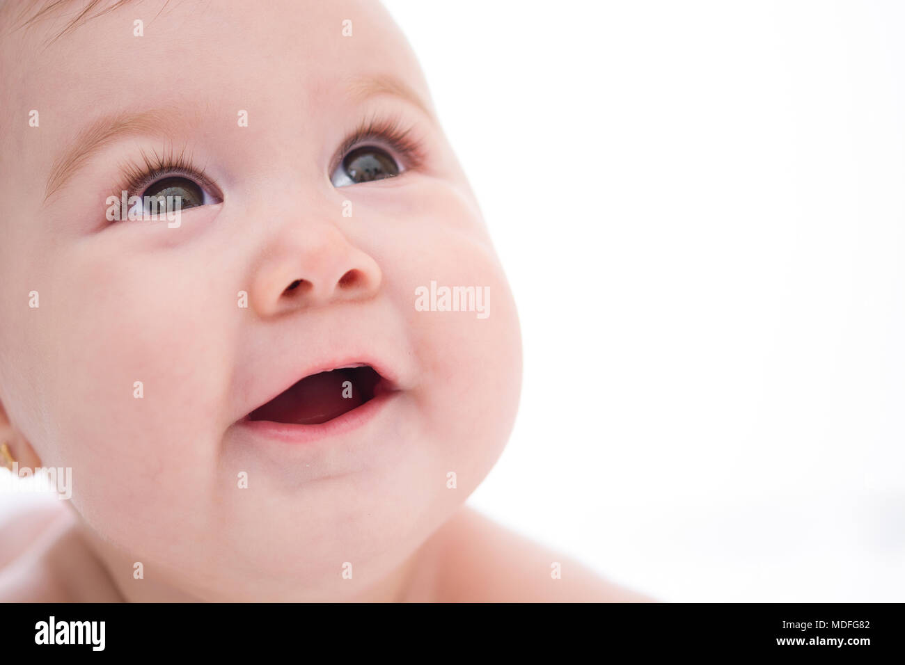 Adorable pequeño bebé chica sonriente sobre fondo blanco Adorable hijita sonriendo sobre fondo blanco. Foto de stock