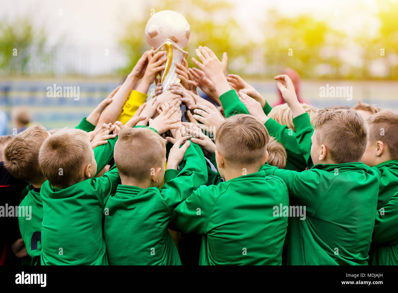 Los niños celebrando la victoria de fútbol. Los jóvenes jugadores de fútbol Celebración del trofeo. Los niños celebrando el campeonato deportivo. Equipo ganador del torneo deportivo para niños Foto de stock