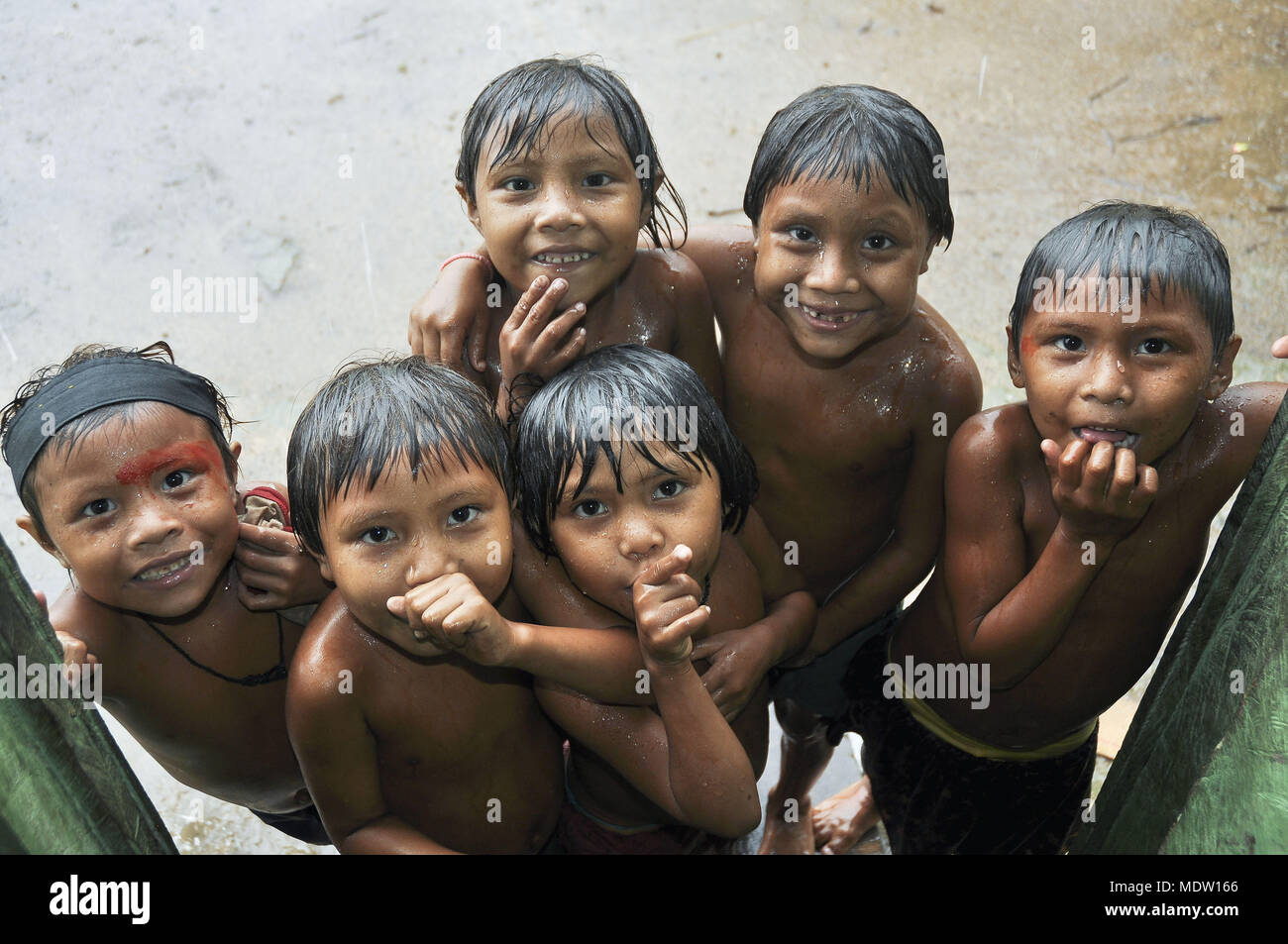 Niños Yanomami bajo la lluvia en la aldea Marari - border Brazilazil - Venezuela Foto de stock