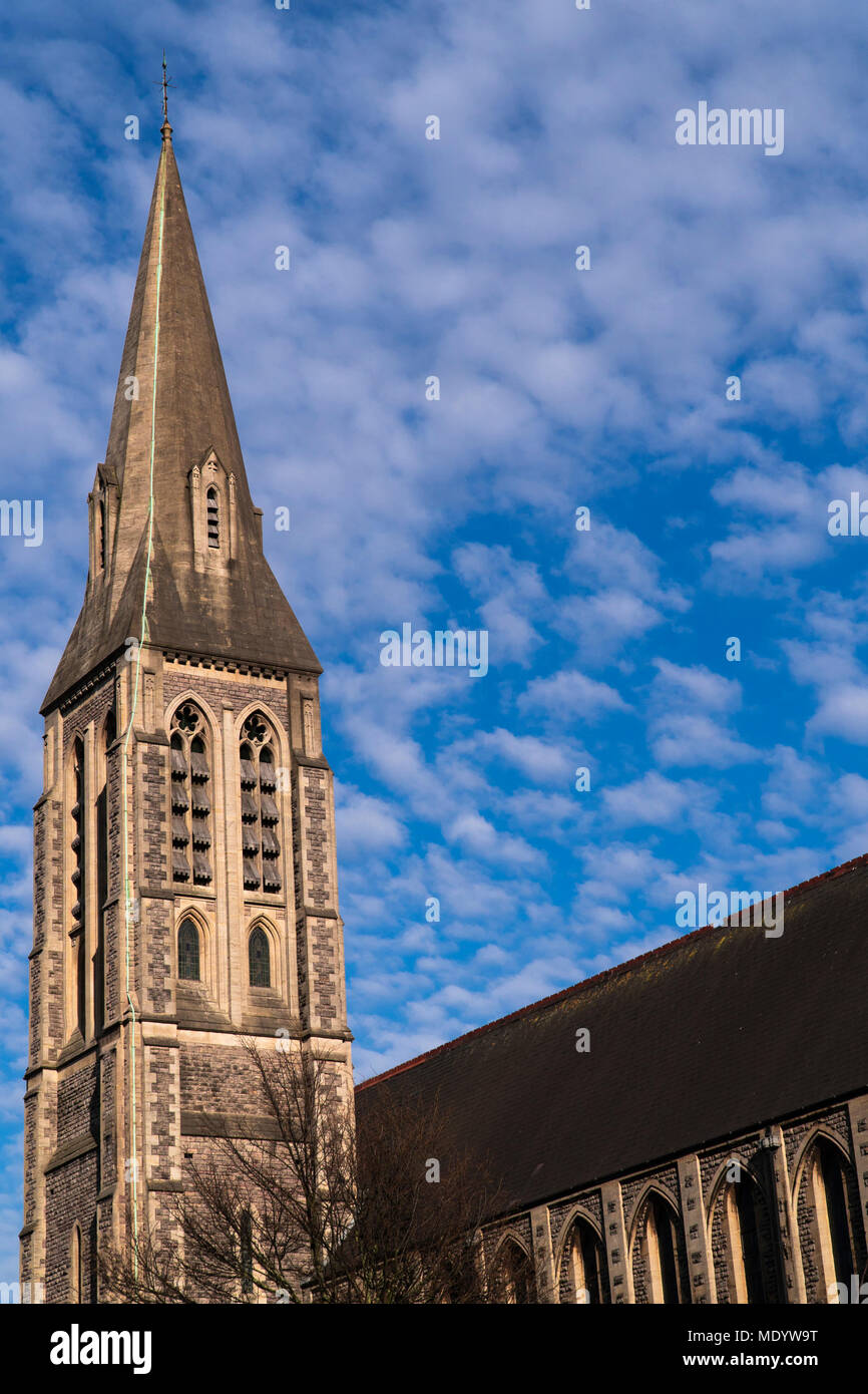 Torre de la iglesia antigua en Cardiff, Reino Unido en el contexto de la sorprendente pantalla nublado en un cielo azul. Foto de stock
