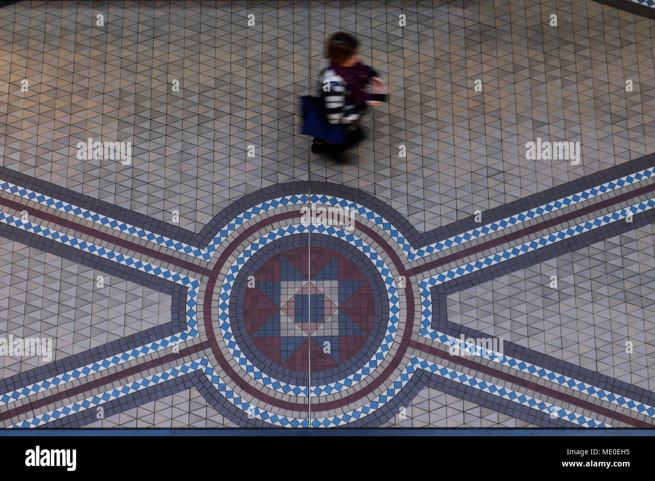 Persona caminando en el piso de baldosas de mosaico en el edificio Queen Victoria en el Distrito Central de Negocios de Sydney, Australia Foto de stock