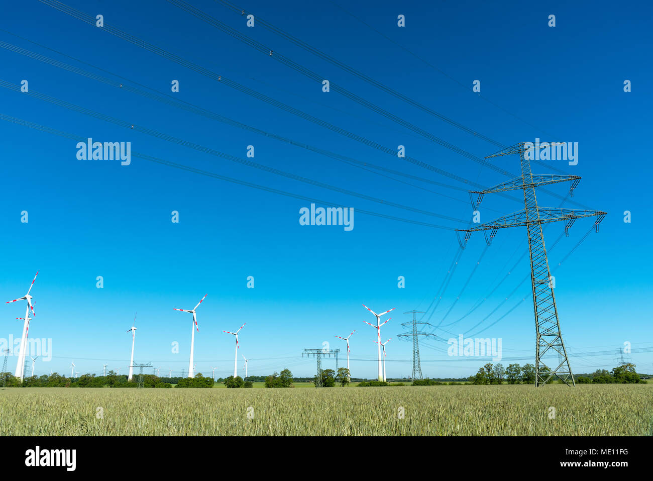 Las líneas de suministro de energía y las turbinas eólicas visto en la zona rural de Alemania Foto de stock
