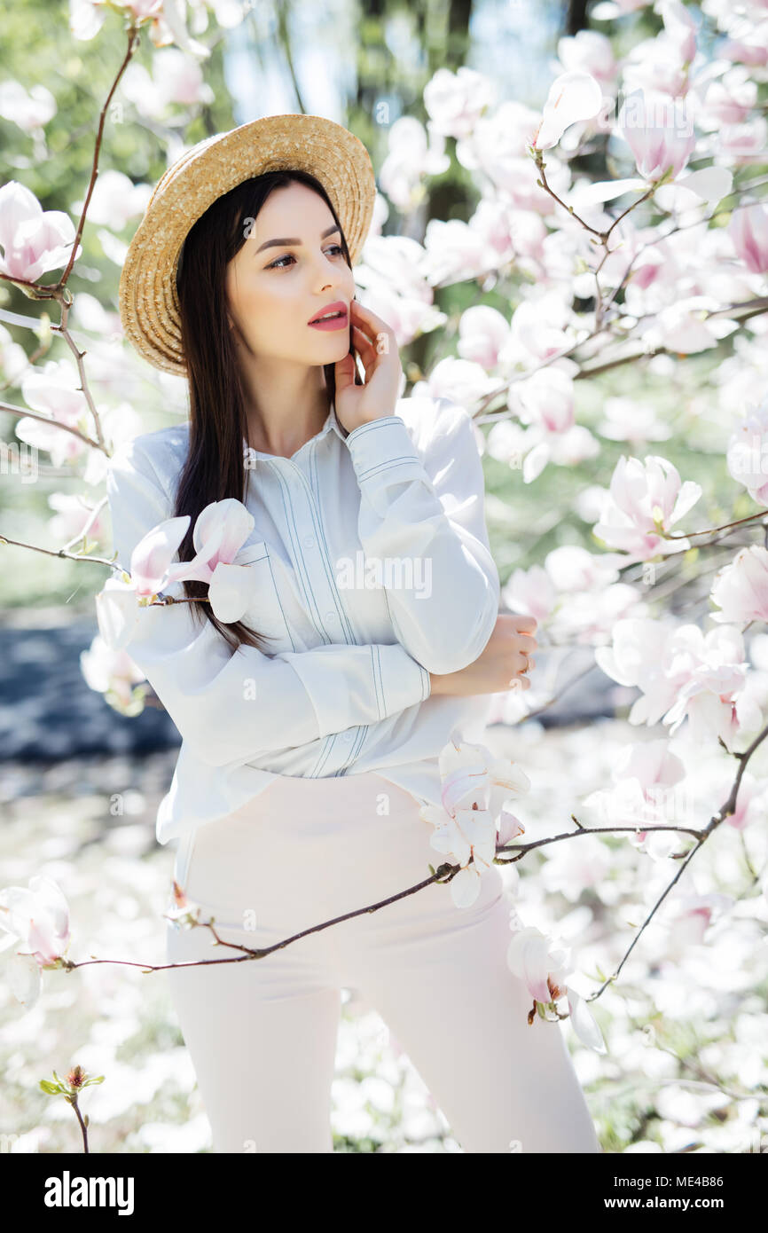 Belleza joven mujer alrededor magnolia flores rosas árbol en spring garden  Fotografía de stock - Alamy