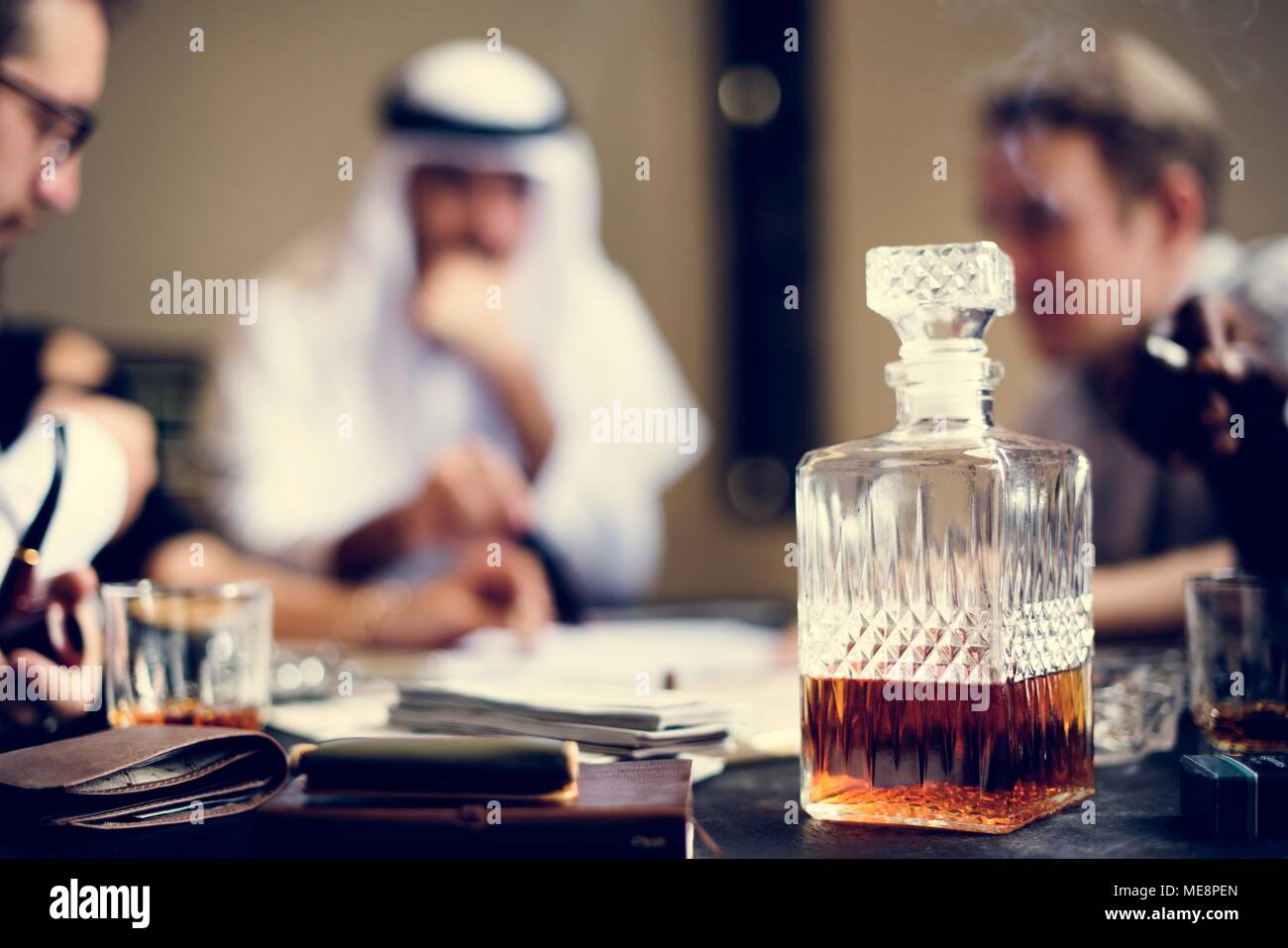 Decantador de Whiskey con empresarios en el fondo Foto de stock