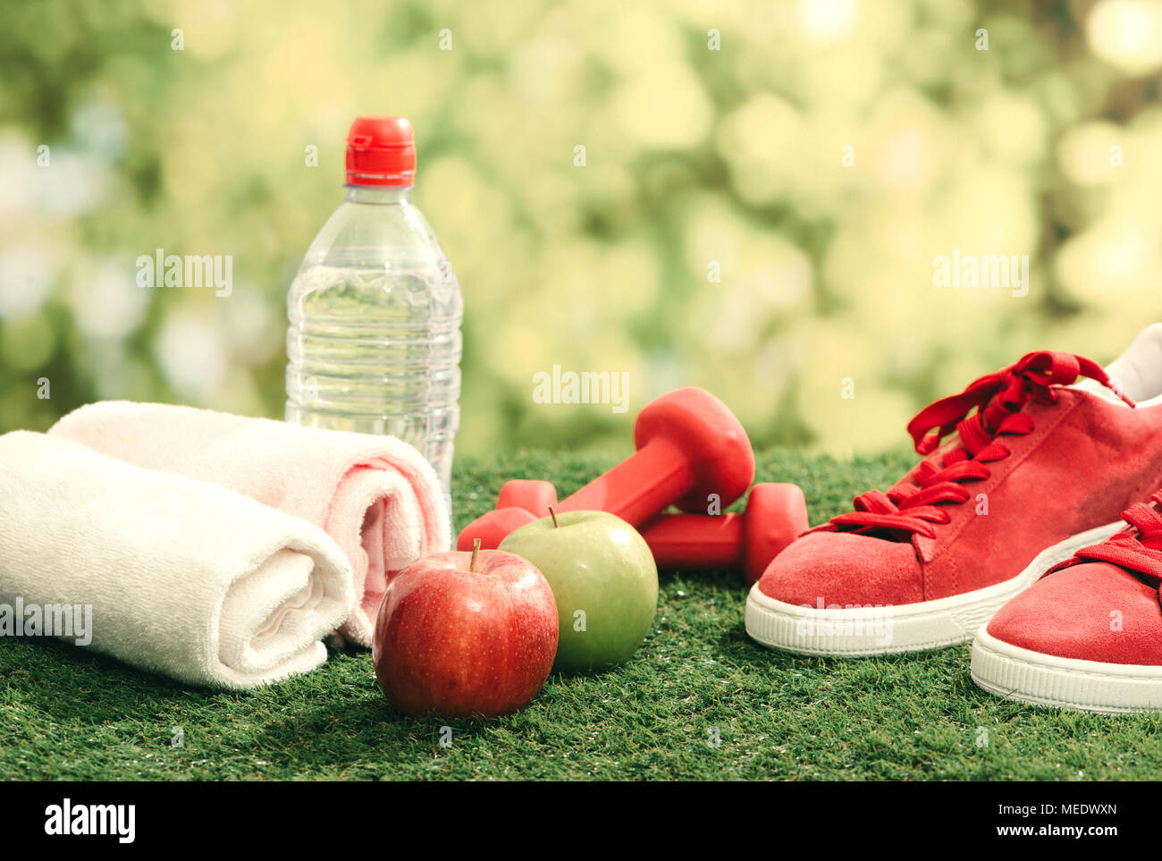 Concepto de fitness con equipamiento de ejercicio sobre el pasto verde de fondo. Foto de stock