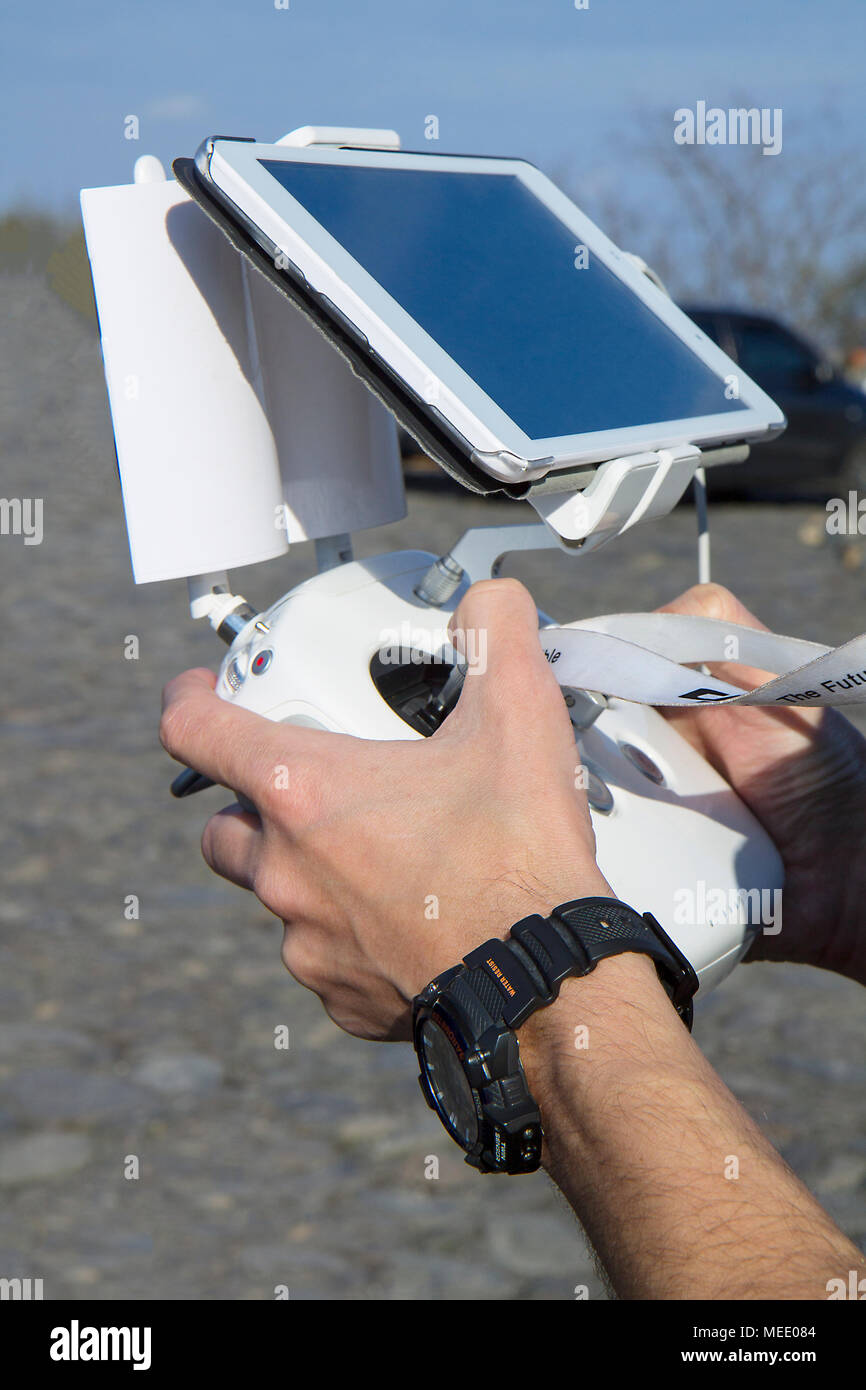Hombre manos sosteniendo el controlador remoto utiliza un tablet para volar  aviones teledirigidos. Cerca en manos de hombres de drone operador con un  hermoso blanco control remoto, vis Fotografía de stock -