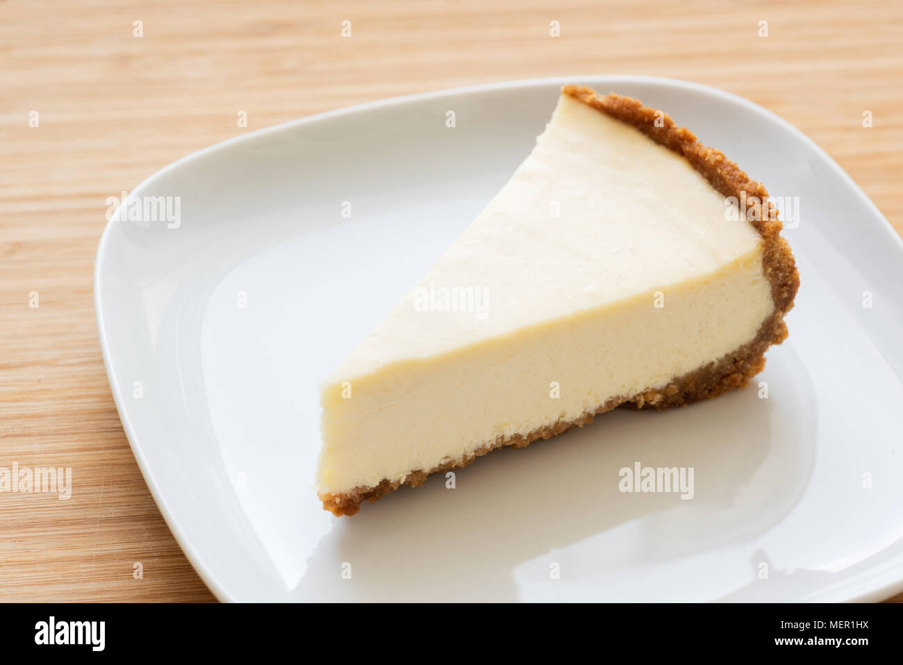 Rodaja de plain cheesecake clásico en la placa blanca. Enfoque selectivo Foto de stock
