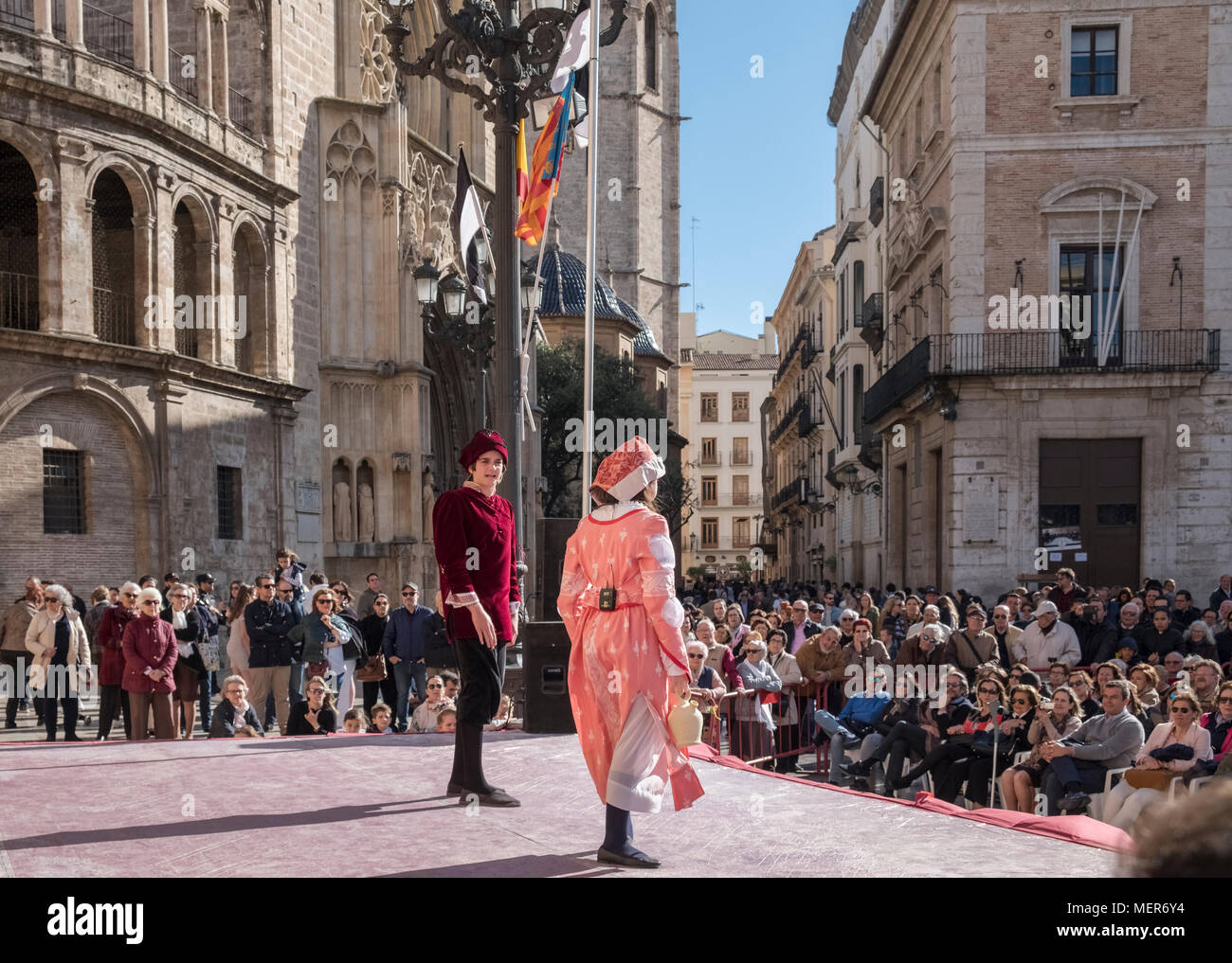 Personas viendo una representación teatral en la Plaza de la Virgen, al norte del distrito de Ciutat Vella, el casco antiguo de la ciudad de Valencia, España. Foto de stock