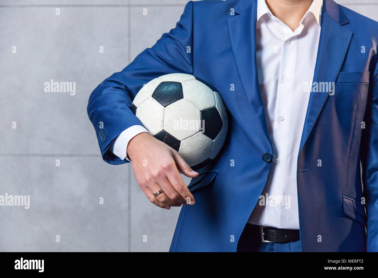 Un Empresario En Un Traje Azul De Pie Cerca De La Pared Y Sostiene