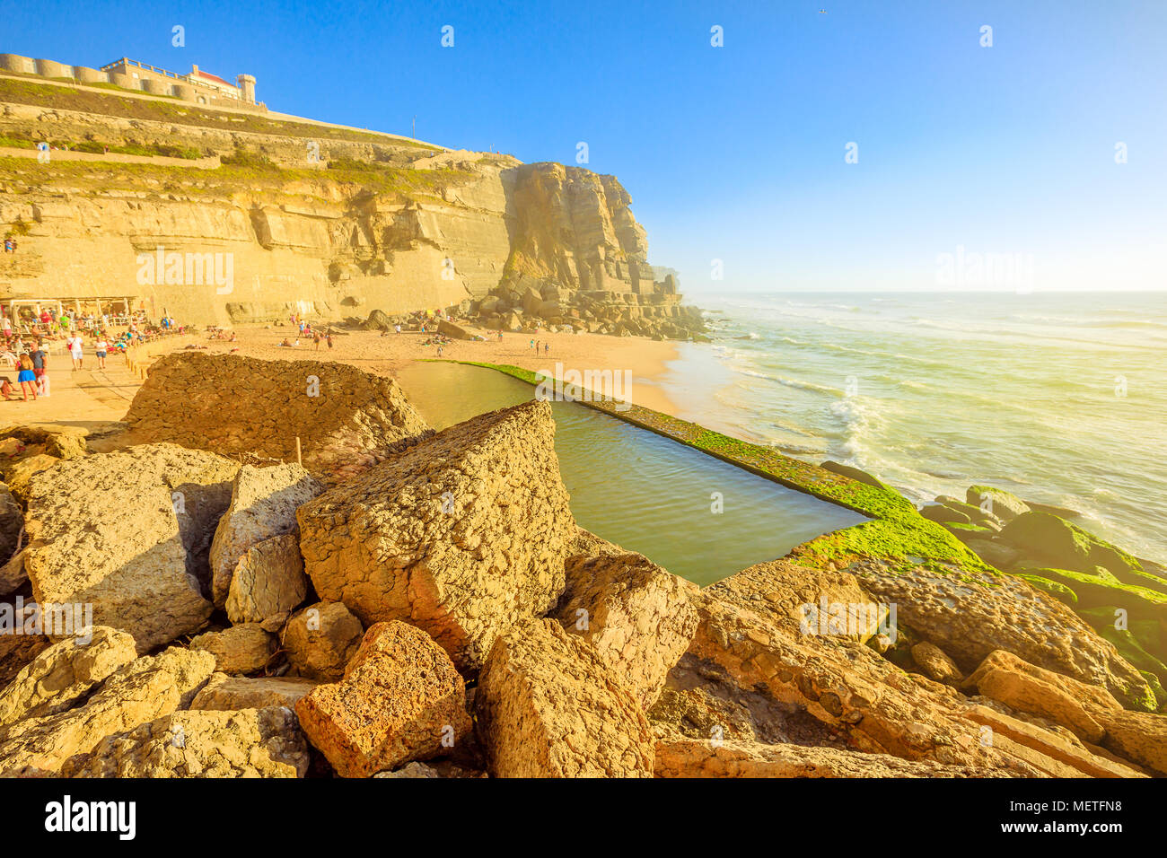 Pintoresco promontorio y playa de la luz del sol de Azenhas do Mar con la  famosa piscina natural visible en marea baja sobre el Océano Atlántico en  Portugal. Portugués popular seaside resort