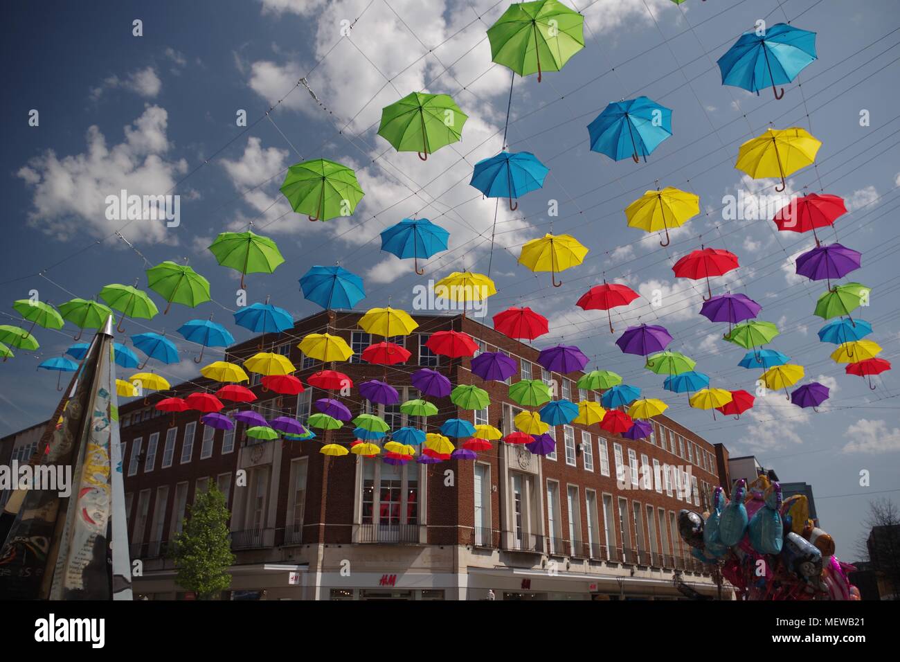La Exeter Enigma y coloridas sombrillas de primavera. Exeter High Street, Devon, Reino Unido. Abril, 2018. Foto de stock