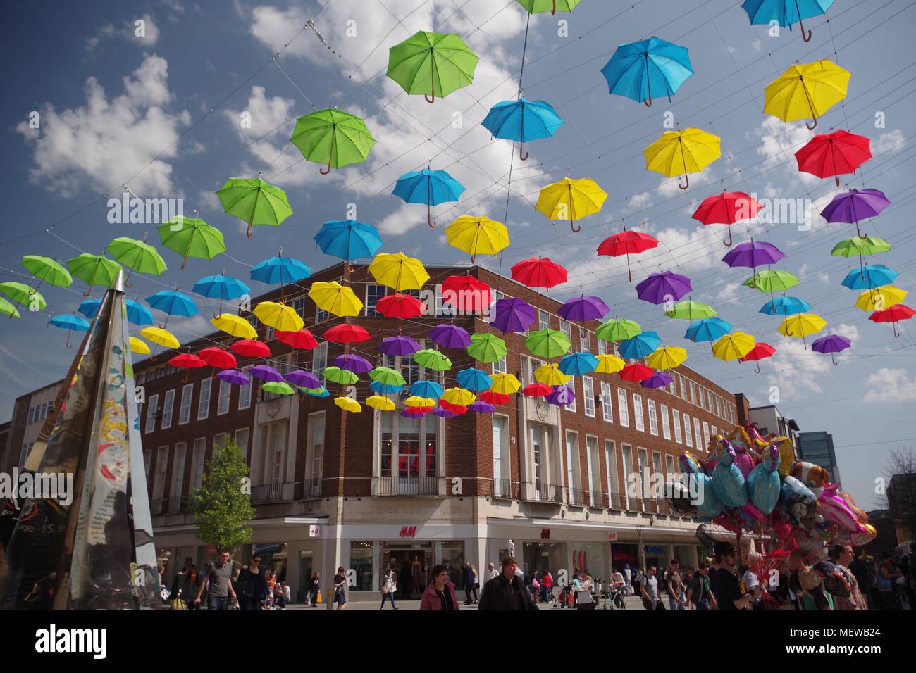 La Exeter Enigma y coloridas sombrillas de primavera. Exeter High Street, Devon, Reino Unido. Abril, 2018. Foto de stock