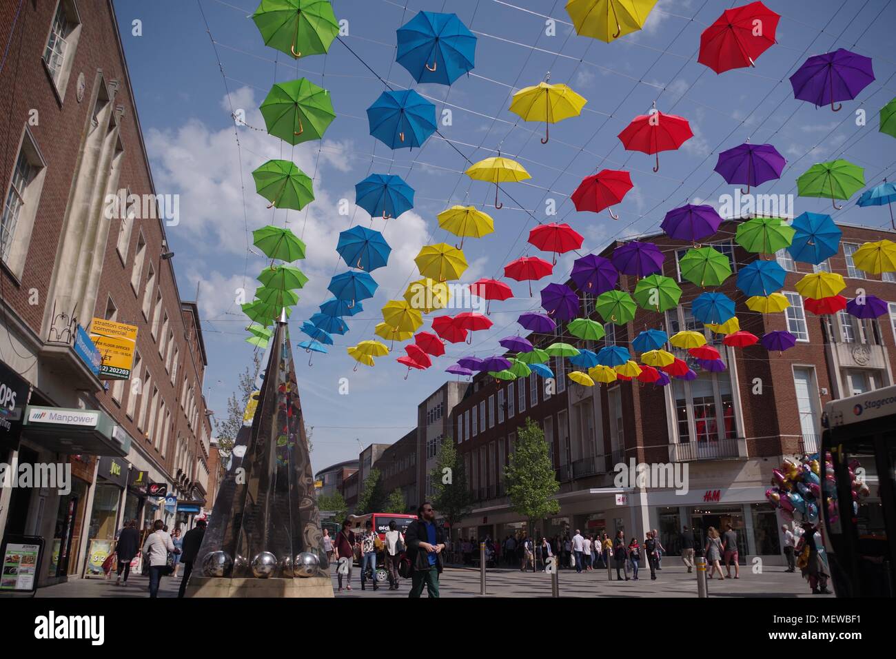 La Exeter Enigma y coloridas sombrillas de primavera. Exeter High Street, Devon, Reino Unido. Abril, 2018. Foto de stock