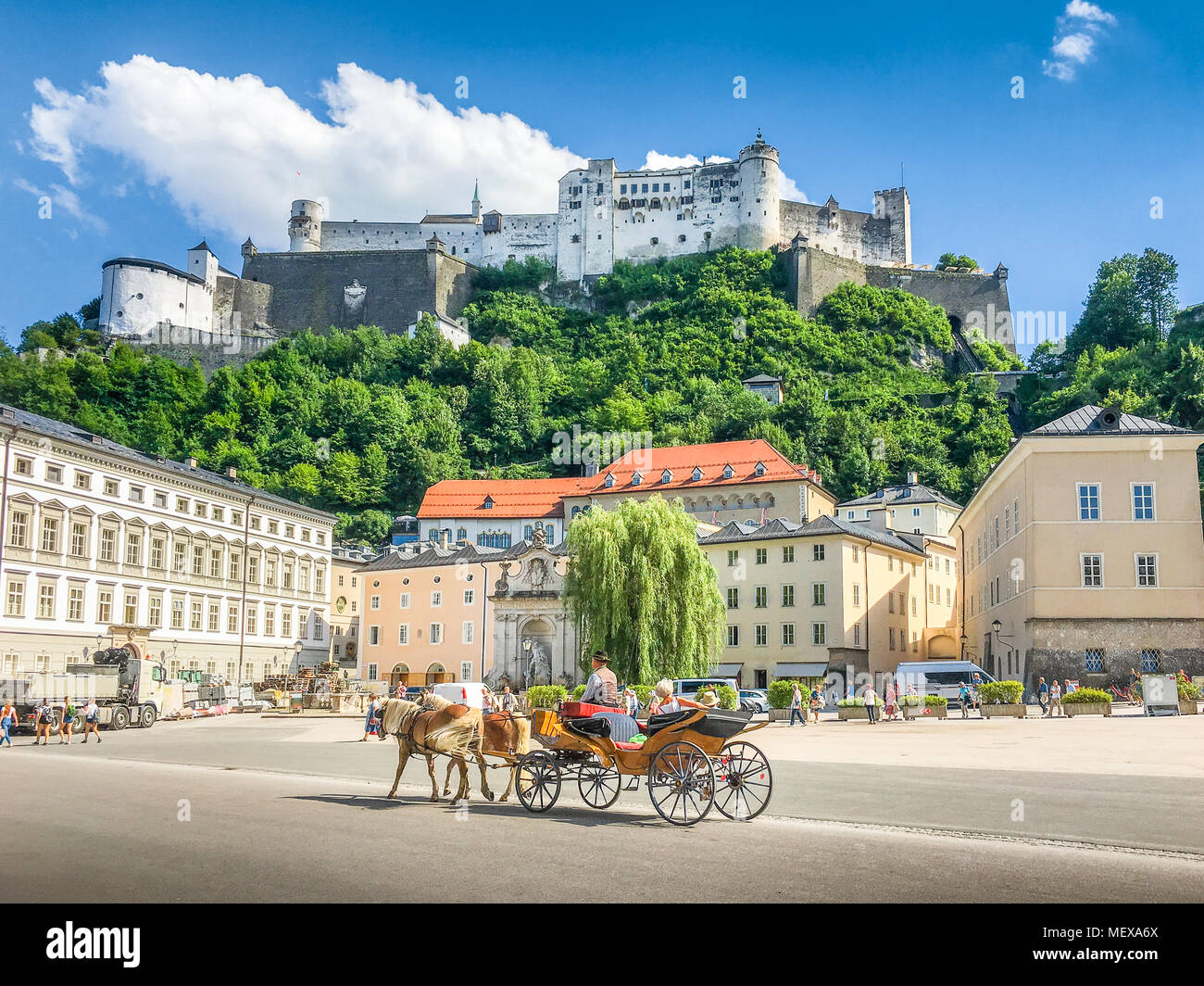 Vista clásica de la histórica ciudad de Salzburgo con tradicional Fiaker carruaje tirado por caballos y la famosa fortaleza de Hohensalzburg en verano, Austria Foto de stock