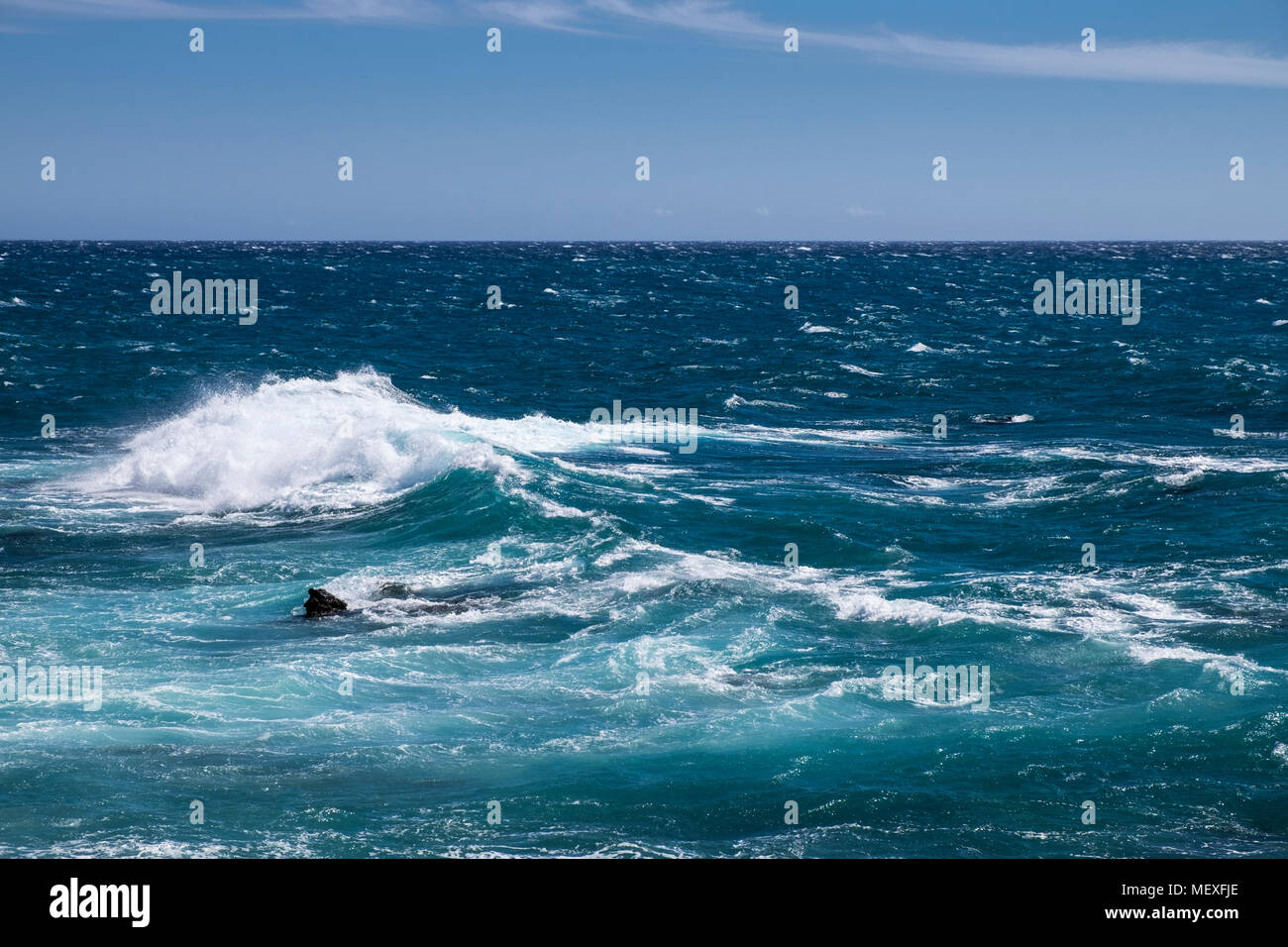 El mar embravecido rompiendo sobre las rocas a lo largo de la costa oeste de Tenerife en Playa San Juan, Islas Canarias, España Foto de stock