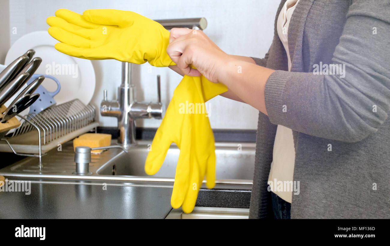 Mujer llevaba guantes de látex amarillo en la cocina Fotografía de stock - Alamy
