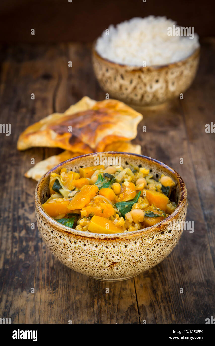 Plato de curry con coliflor, calabacita calabaza, espinaca y cilantro, papadam y arroz Foto de stock