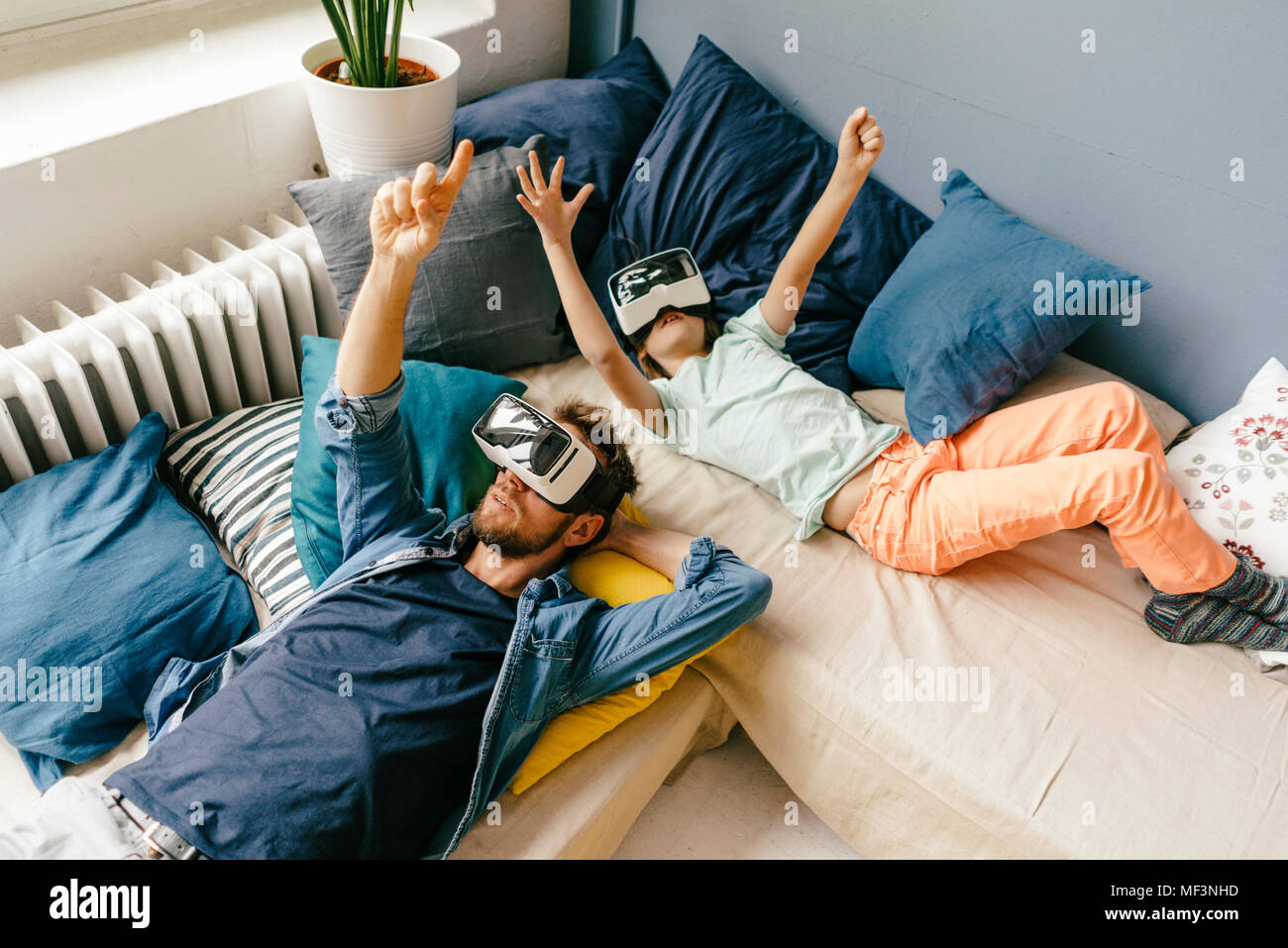 Padre e hijo llevaba gafas VR acostado en casa Foto de stock