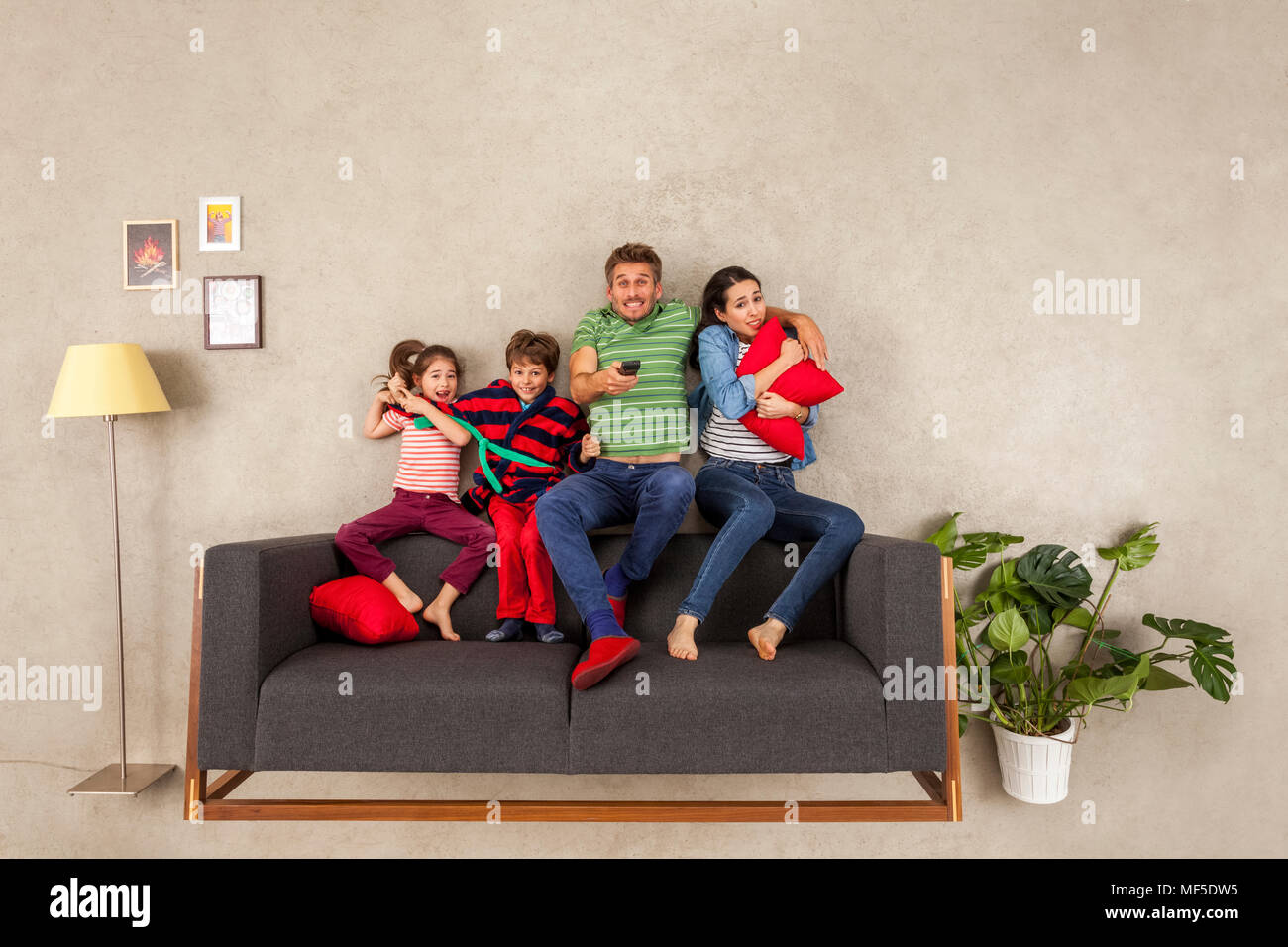 Familia con dos niños viendo la televisión juntos Foto de stock