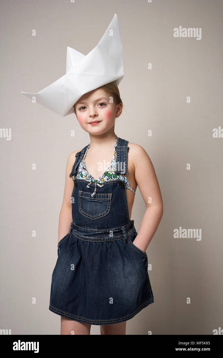 Retrato de niña de moda con un gran barco de papel sobre su cabeza  Fotografía de stock - Alamy