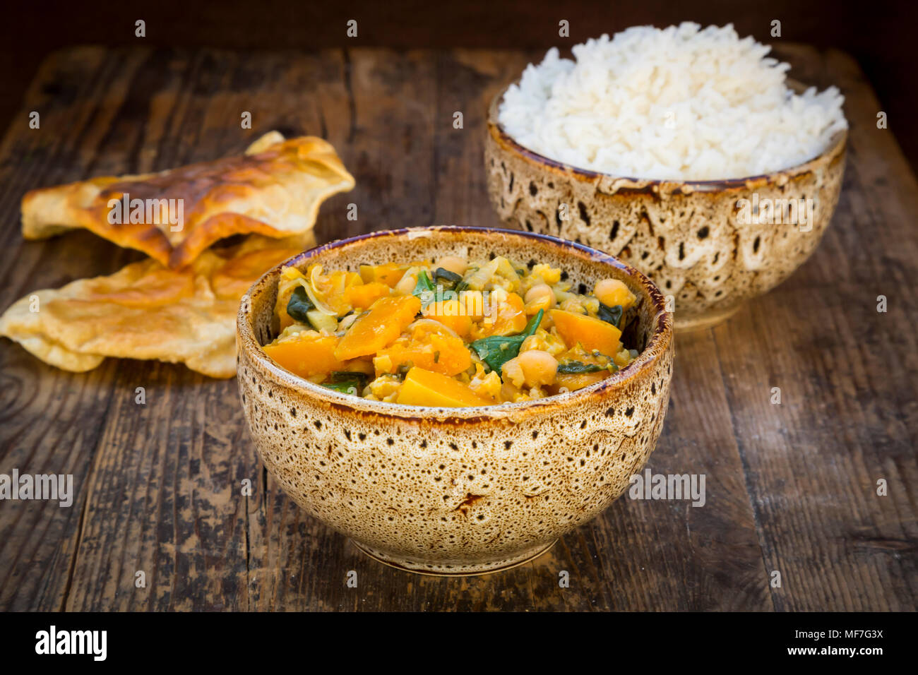 Plato de curry con coliflor, calabacita calabaza, espinaca y cilantro, papadam y arroz Foto de stock