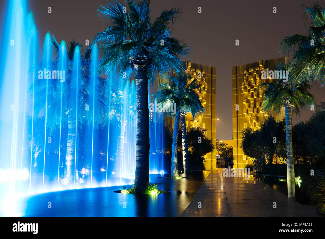 Al Shaheed Park, Kuwait. Fuente de noche show de luces. Constitución monumento en el fondo. Foto de stock