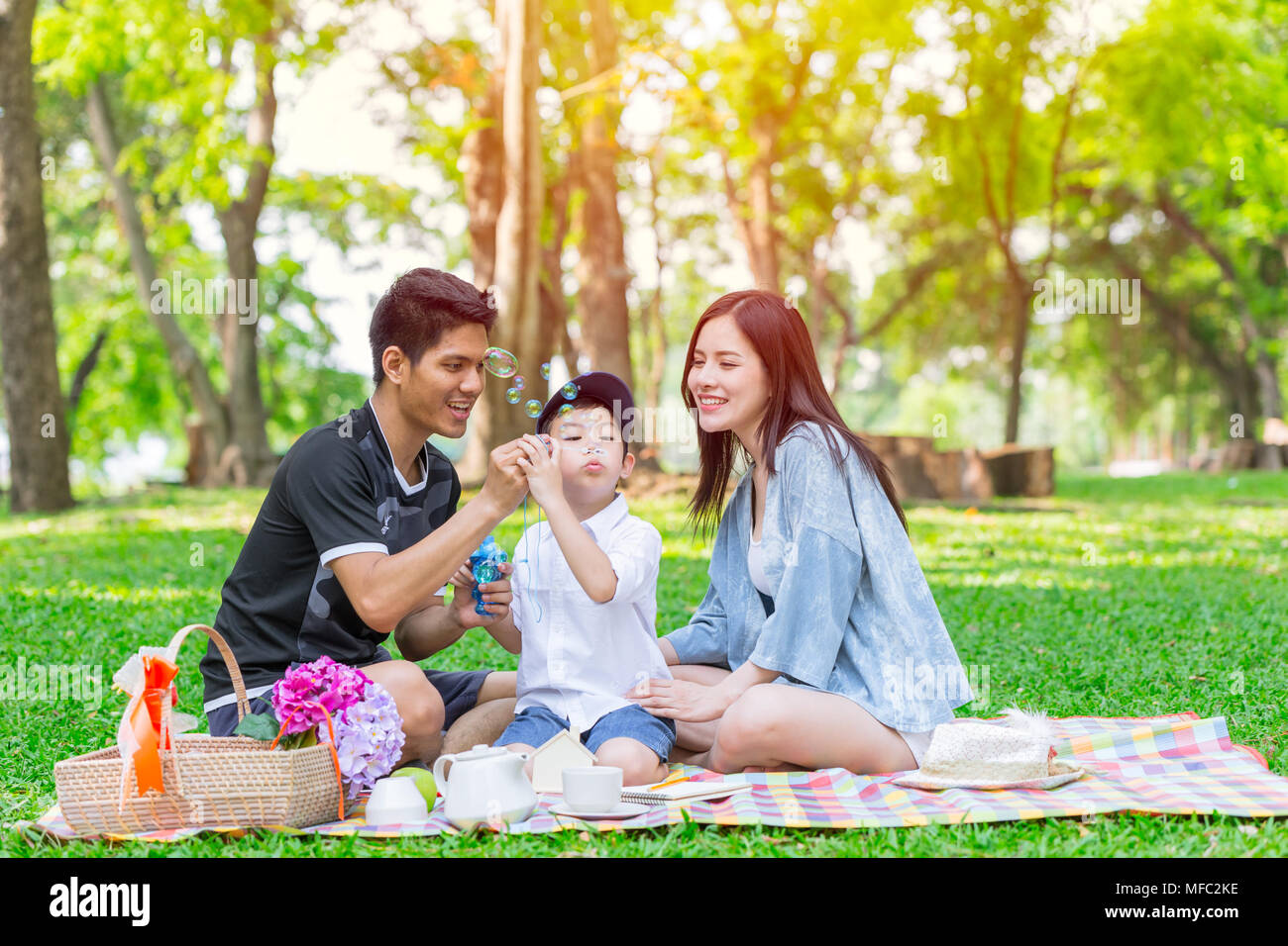 La familia una adolescente asiática kid felices vacaciones momento de picnic en el parque Foto de stock