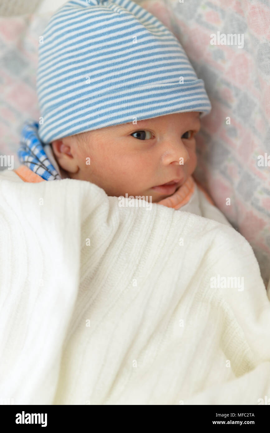 Eurasia Lindo Bebe Recien Nacido Nino Acostado En La Cama Y Llevaba Una Tapa De Rayas Fotografia De Stock Alamy