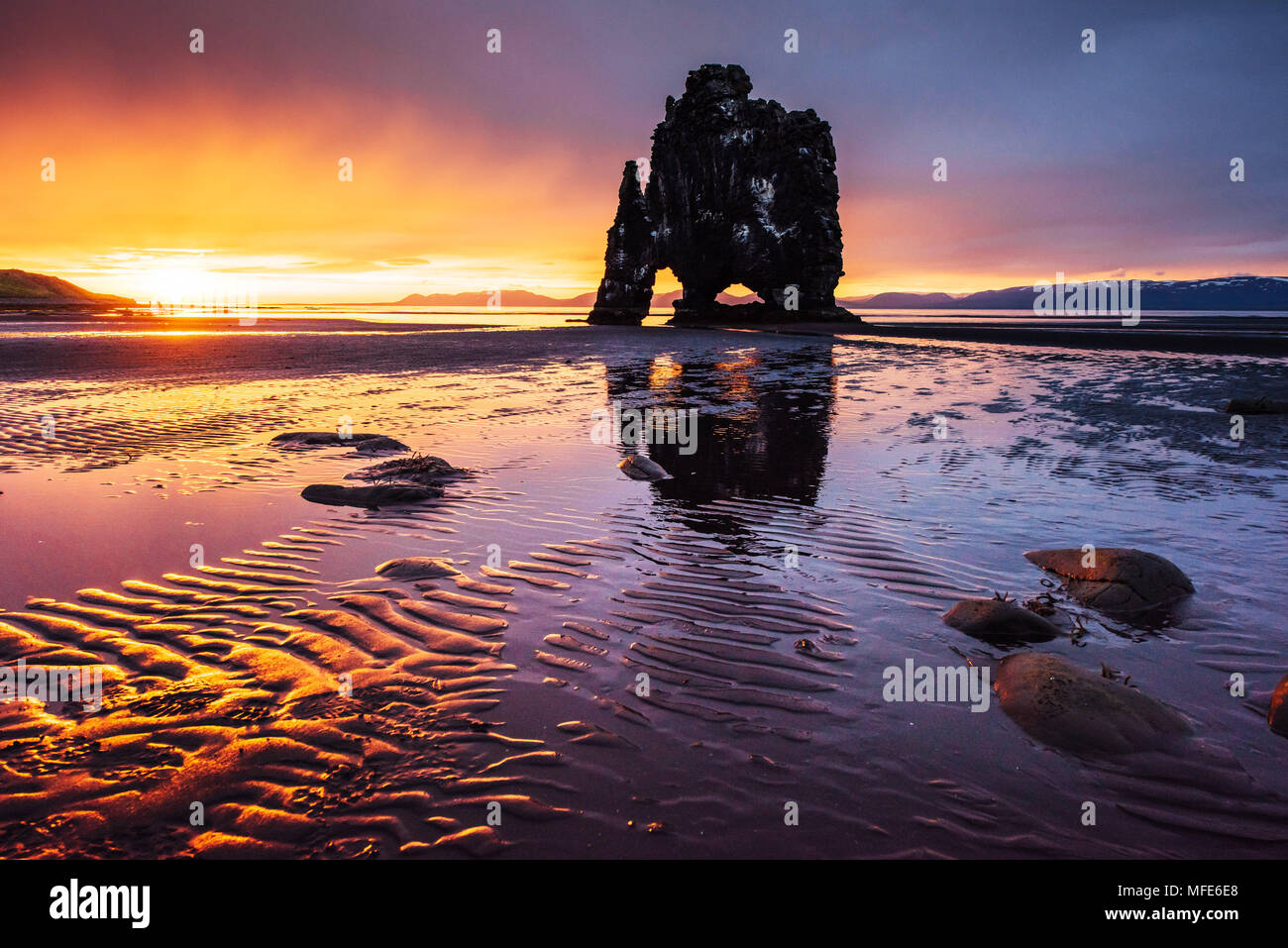 Es una espectacular roca en el mar, en la costa norte de Islandia. Las leyendas dicen que es un troll petrificado. En esta foto Hvitserkur se refleja en el agua del mar después de la puesta de sol de medianoche Foto de stock