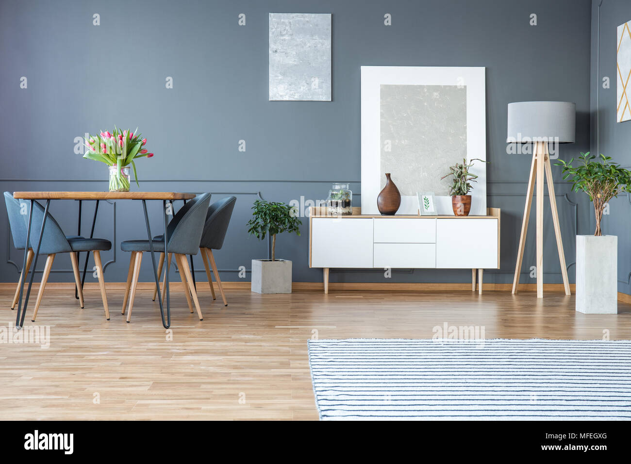 Tulipanes rojos sobre la mesa de madera en color gris plata comedor  interior con pintura blanca en la alacena Fotografía de stock - Alamy