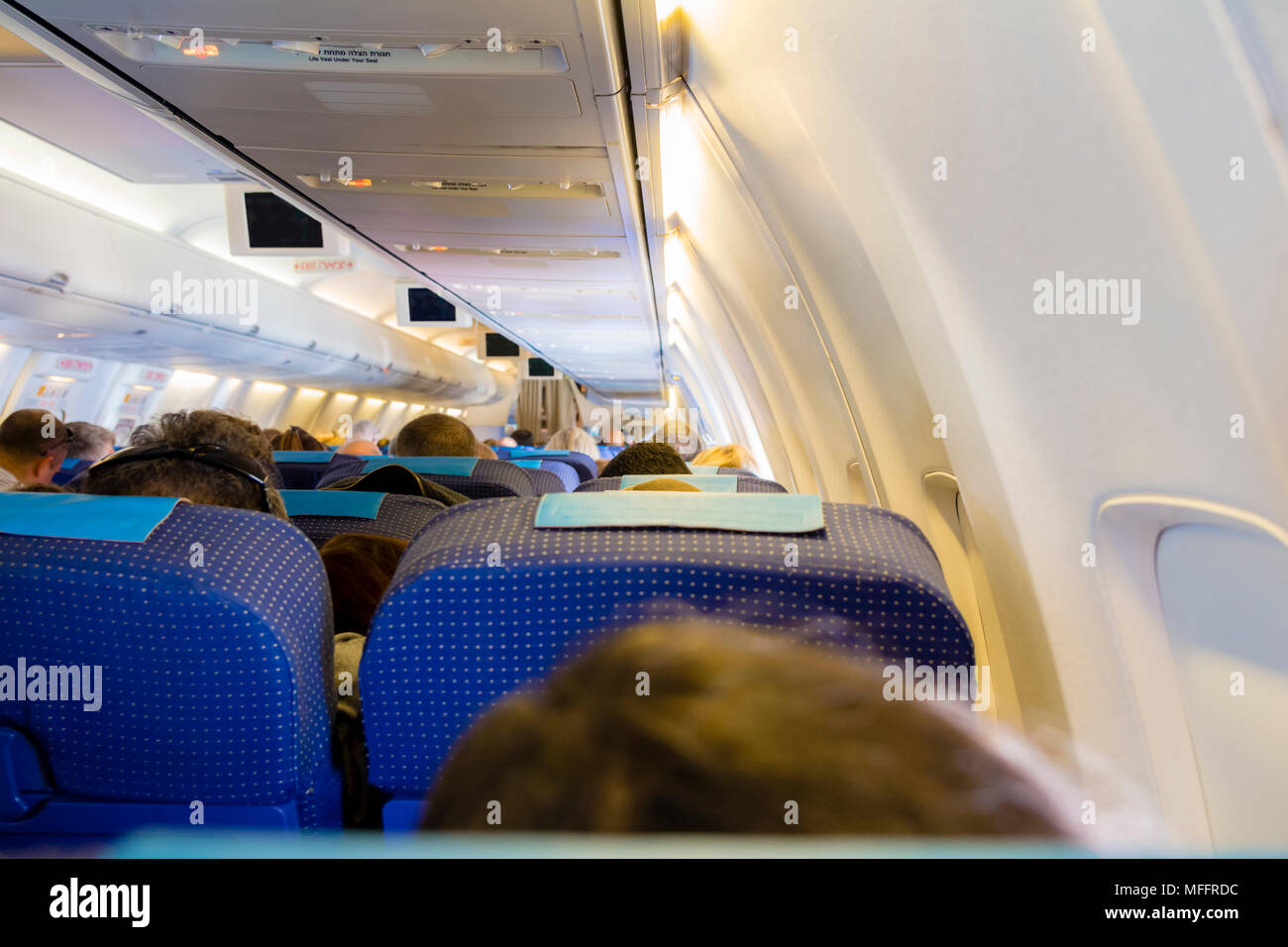 Interior del avión de pasajeros con gente en los asientos. Foto de stock
