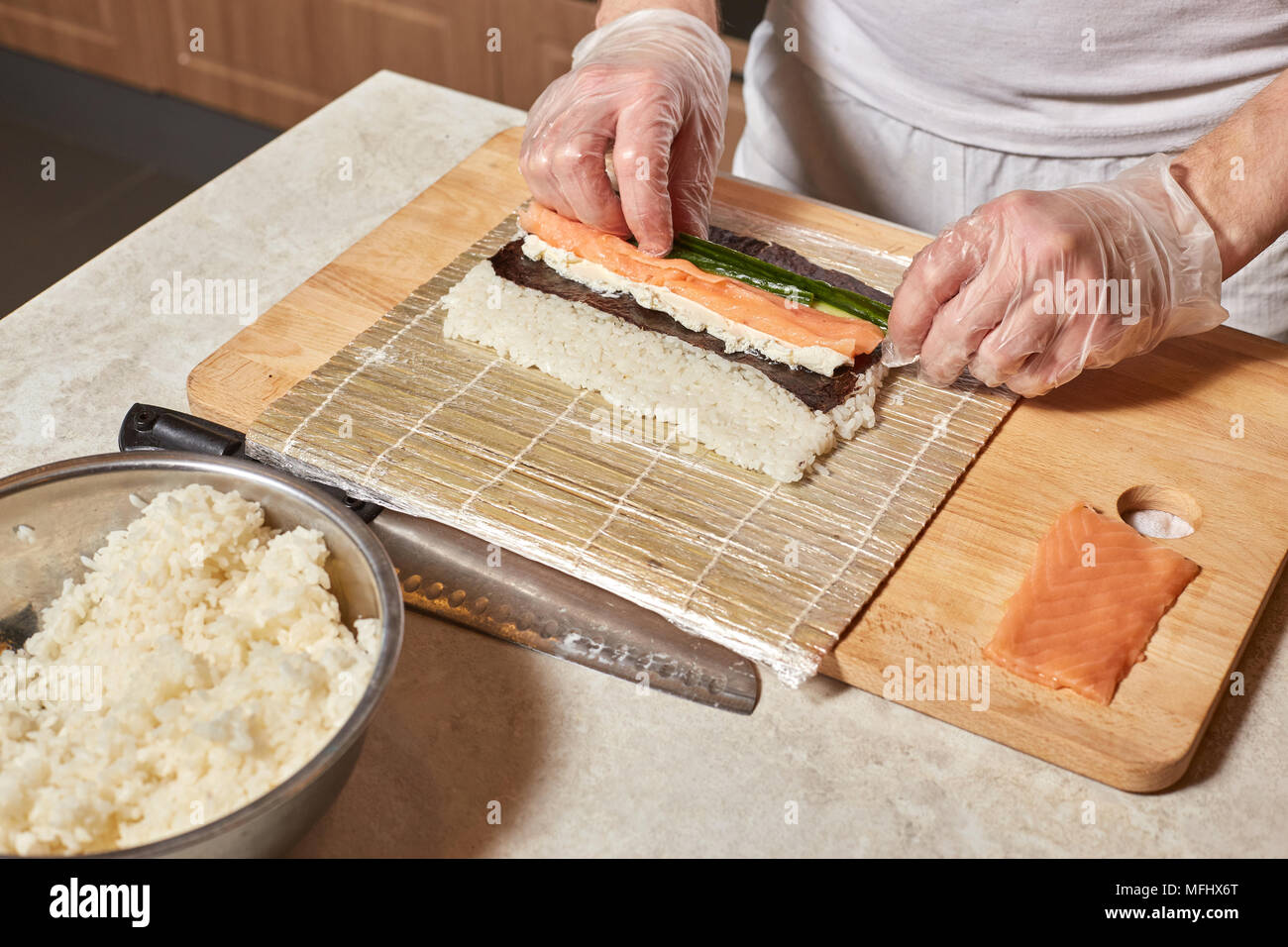 Proceso de hacer sushi. Las manos de chef preparar rollos con