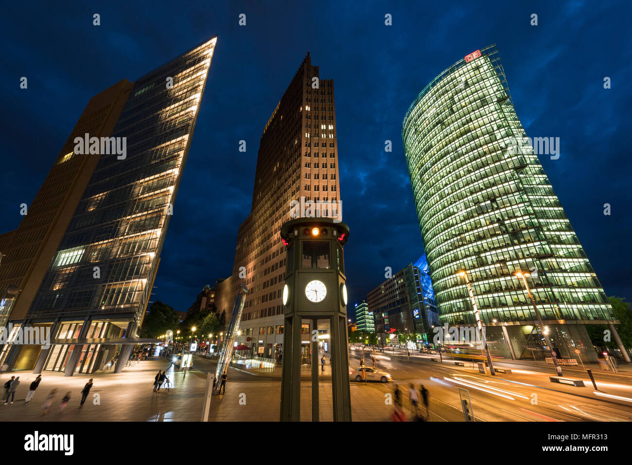 Berlín. Alemania. Potsdamer Platz, vista nocturna de rascacielos y la réplica de la torre de luz de tráfico históricos / reloj, diseñado por Jean Krämer, y hecho Foto de stock