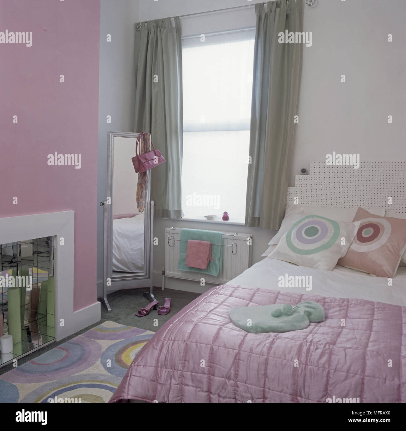 Dormitorio verde y rosa con cojines y alfombras estampadas Fotografía de  stock - Alamy